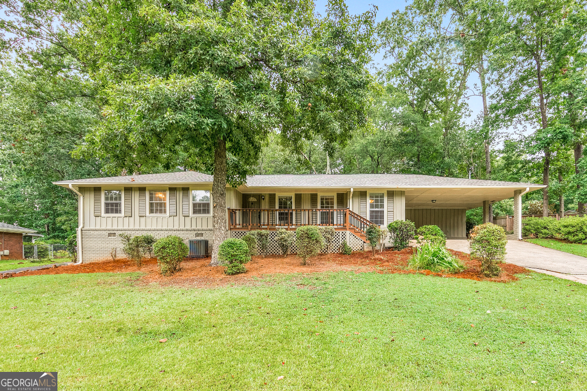 Welcome to 1556 Smithwood Drive, a charming 3 bed / 2.5 bath ranch home tucked away on a quiet street in East Cobb. This well-maintained property welcomes you with hardwood flooring throughout and a formal sitting room just off the foyer. The fireside living room creates a warm and inviting atmosphere ideal for everyday living or entertaining. Cooking is a delight in the updated kitchen featuring white cabinetry, stainless steel appliances, and a bright, open layout with plenty of natural light. The primary suite serves as a peaceful retreat, complete with a private en suite bath featuring a jetted tub and separate shower. Two additional bedrooms and a full bath provide comfortable accommodations, all conveniently located on one level. Step outside to a peaceful, wooded backyard where the patio area offers a quiet spot for morning coffee, outdoor dining, or simply enjoying the fresh air. A detached garage offers added convenience and storage space. Located in a great neighborhood within the Sprayberry High School district, with easy access to shopping, dining, and more.