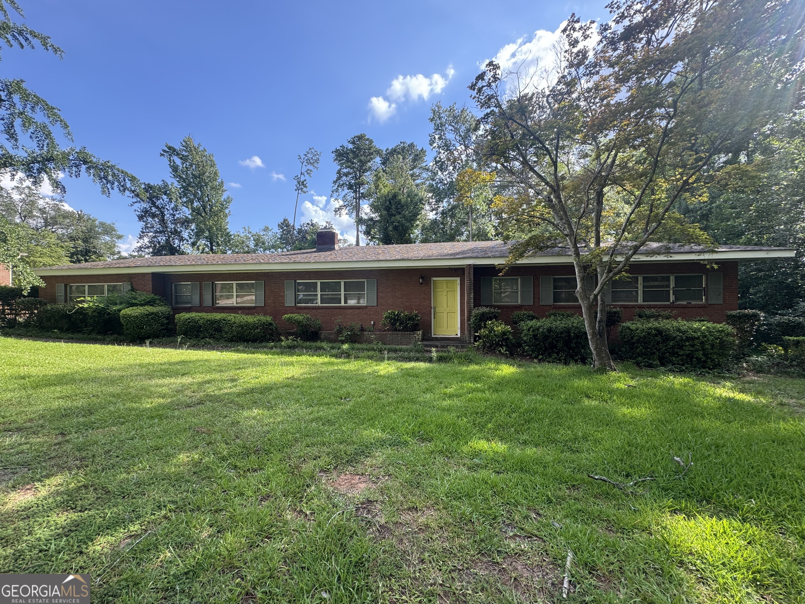 IN TOWN CONVENIENCE WITH A MID CENTURY FLAIR!!! This Partially Updated 4/3.5 Home has over 2600 sq ft of stylish living space. Located in the heart of town in a well established neighborhood, this brick beauty has a new kitchen , granite countertops, wood floors, a huge primary suite on the second level with an en suite bath featuring soaking tub, travertine tile, and separate shower!! The gracious lot is 1.15 acres full of trees and mature landscape. Call to schedule a tour.