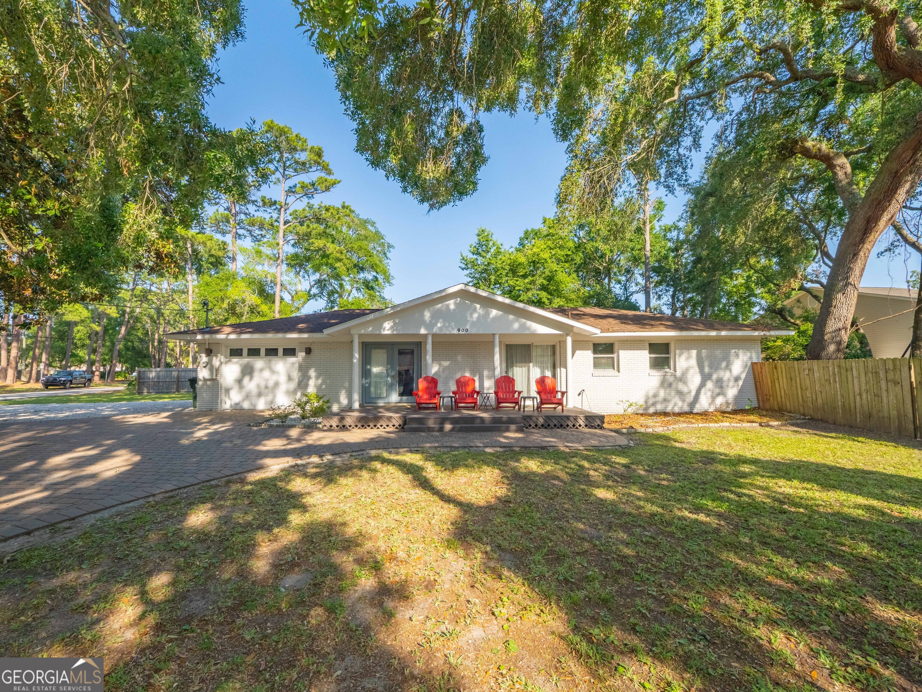 IDEAL Vacation RENTAL / Investment / Second Home! The thoughtful layout includes two separate living areas-perfect for multi-generational living, a guest suite, or potential rental income. Located in the heart of St. Simons Island, this fully renovated and fully furnished ranch cottage sits in the highly desirable south end-just a short stroll from the Village, where you'll find some of the island's best restaurants, shops, the pier, lighthouse, and beach. This charming one-level home offers an ideal blend of flexible space and coastal comfort. The front unit features a chef's kitchen, cozy den, three bedrooms, and one and a half baths. The rear unit includes a spacious open living area, a large bedroom with beautiful inlaid tile, and an en suite bath finished with elegant Italian marble. Outside, the oversized corner lot offers privacy fencing between the two living areas, two separate driveways, and ample parking-perfect for entertaining or extended stays. There's plenty of room to expand, whether you dream of adding a pool, garden, or additional structure. A welcoming front porch with Adirondack chairs invites you to relax and take in the easygoing island lifestyle. Located in an X flood zone with no HOA and no rental restrictions, this home gives you the freedom to create your own coastal getaway, investment property, or both.