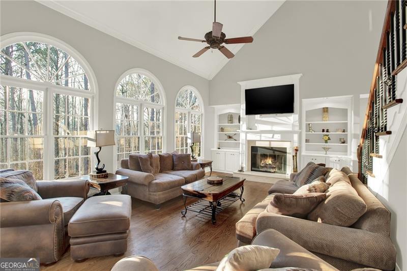 Beautiful home in sought after Fariways at Towne Lake. This home features a Chef's kitchen, 5 burner cooktop with griddle, double ovens, granite counters, tiled backsplash, wine rack & under cabinet lighting. Eat in breakfast area. Hardwood floors throughout the main floor. Formal living room & Separate dining room that fits 10+ easily. Family room is grand with cathedral ceilings & a fireplace w/built in book cases. Wrought iron spindles, upgraded light fixtures. Upstairs consist of Oversized master bedroom with sitting room. Master spa features Italian tiled floors and shower, granite tops and designer sinks w/ double vanities. 3 spacious secondary bedrooms. In law suite in the finished basement with kitchenette. Basement has additional family room with a fireplace. Huge covered screened in porch, fenced in yard, and much more!! Close to shopping, schools, & parks. Need updates or repairs? Seller has dropped 70K Come see today!