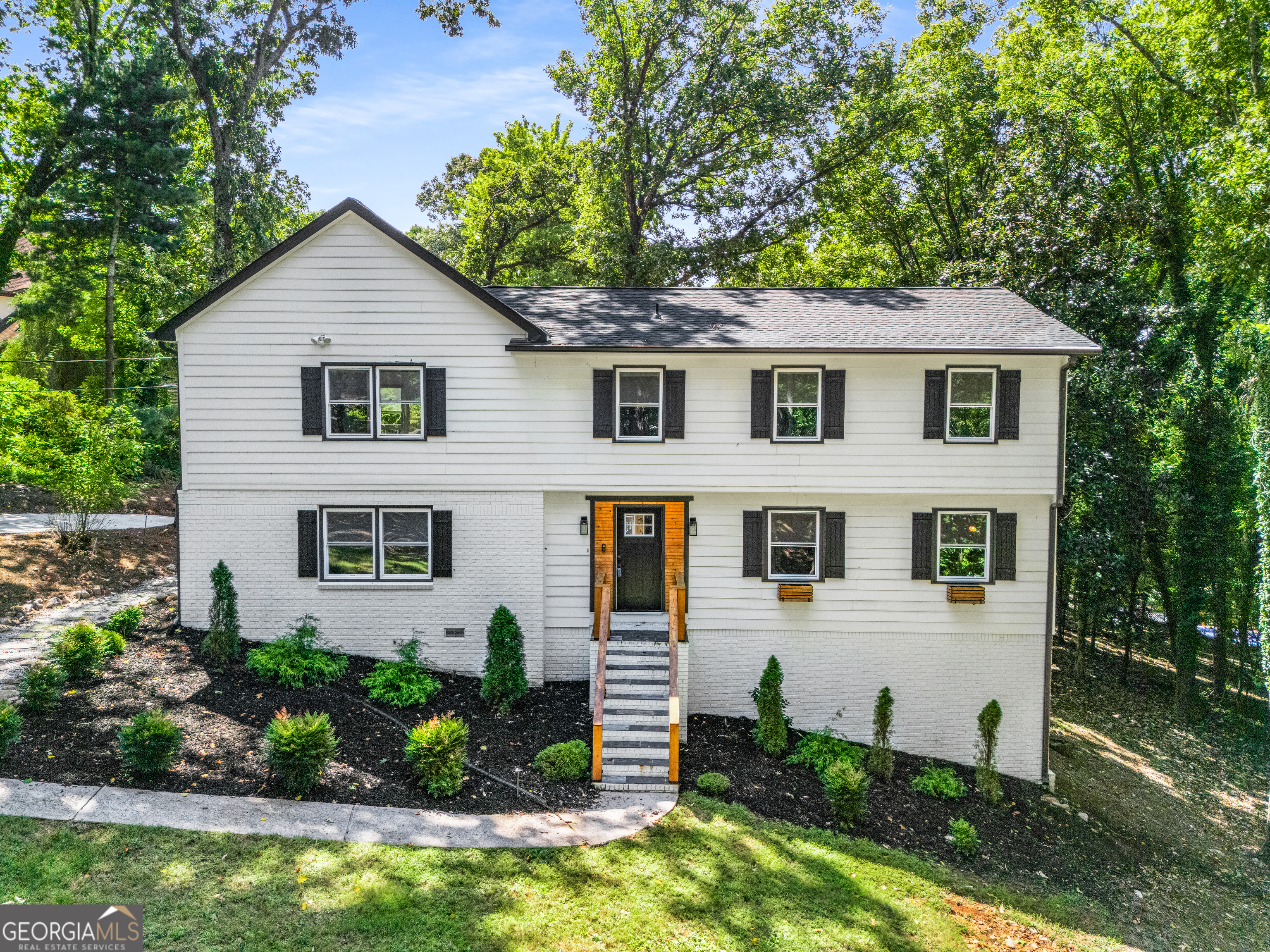 Tucked away at the end of a quiet cul-de-sac, this Marietta gem offers the rare combination of privacy, space, and style. Set on .79 acres, the home welcomes you with updated interiors, and an outdoor retreat featuring a sparkling in-ground pool and multiple decks perfect for entertaining. All just minutes from the charm and energy of Marietta Square-this property is a true sanctuary with city convenience. Step into a light-filled interior designed for both everyday living and memorable gatherings. The heart of the home is an updated kitchen with crisp white cabinetry, quartz countertops, stainless appliances, a pantry, and a casual breakfast bar-ideal for morning coffee or evening wine. Hardwood floors, and crown molding add warmth and character, while a cozy fireplace anchors the inviting second living room. The layout is smart and flexible, offering five bedrooms and three full baths. A main-level suite is perfect for guests or multigenerational living, while the oversized primary suite upstairs offers a true retreat with vaulted, beamed ceilings, and its own private deck. This property was made for enjoying the outdoors. Multiple decks overlook the large pool, creating a resort-like setting right in your backyard. The wooded lot adds privacy and a natural backdrop for summer cookouts, and pool parties. With no HOA, you have the freedom to make this home your own. Two car garage and extra long driveway. Enjoy comfortable, fun living, and the convenience of being less than 3 miles from the Marietta Square's dining, shopping, and events!