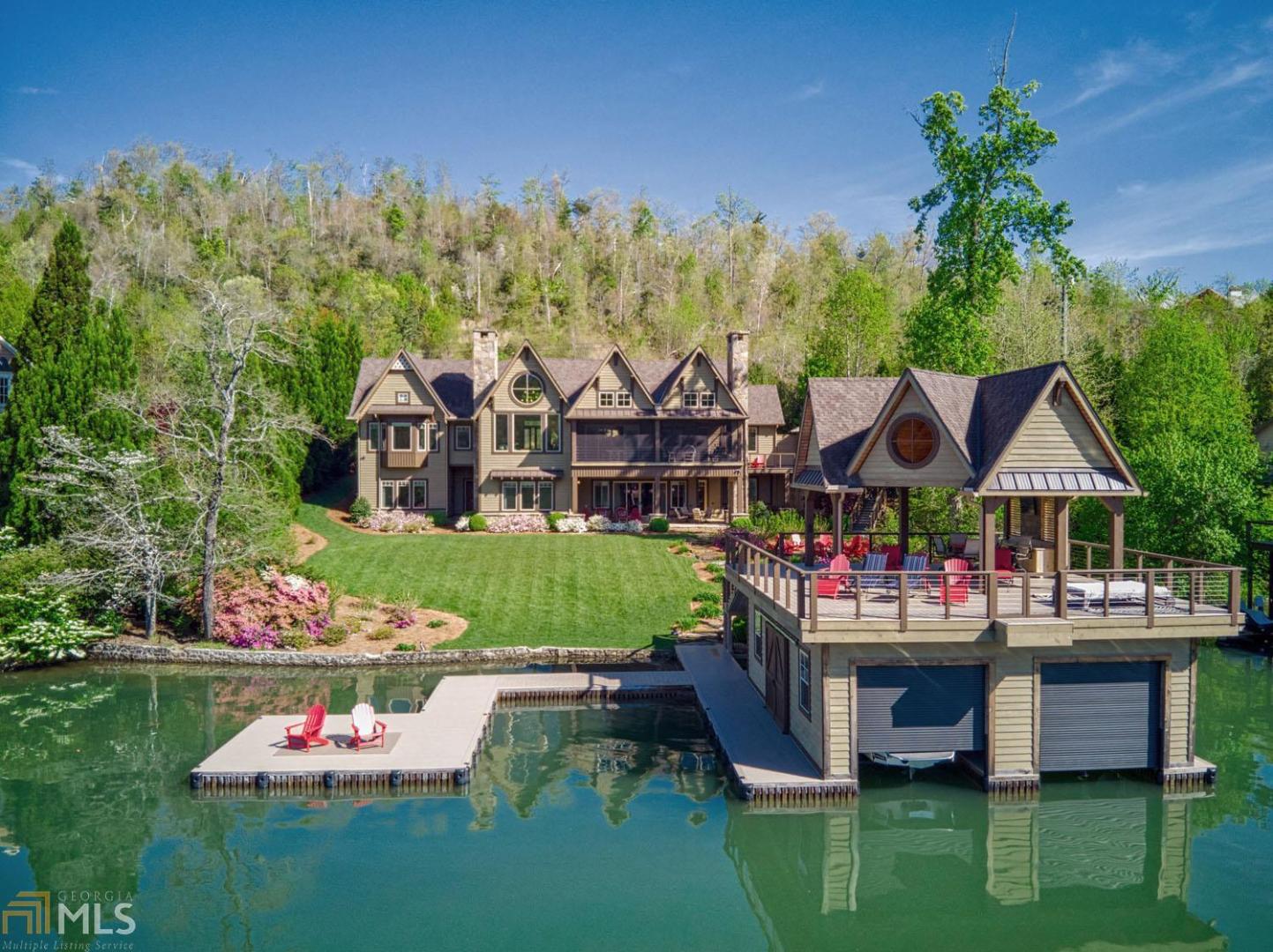 Enjoy sunsets from this custom home on a level lot on Lake Burton's big basin. The great room features vaulted distressed shiplap ceilings, plastered walls, hammered timbers, oak flooring, stone fireplace & picture windows framing lake views. The gourmet kitchen boasts barn wood cabinetry, wet bar & pass-through window to screened porch with fireplace. Main floor owners' suite offers lake views & bath with separate vanities, tub & oversized shower. Main floor amenities include a guest bedroom with private bath, office, laundry, half bath & 2-car garage. Upstairs is a home theatre with stadium seating & full bath. The terrace level provides 3 guest suites, a family room, wet bar, laundry room & patio overlooking the level lawn, fire pit & 2-story boathouse.
