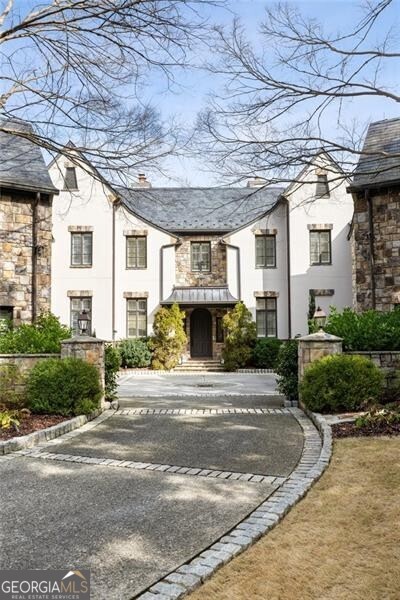 Behind the gated entrance of Buckhead's exclusive 675 West Paces Ferry enclave, recently renovated home No.8 offers European-inspired elegance with soaring 12ft ceilings, extensive millwork and moldings, exposed wood beams, intricate limestone mantles, custom cabinetry and built-ins. A bright and spacious main level is centered around the impressive great room, adjoining dining room, and expansive eat-in kitchen open to a cozy keeping room, screened porch complete with grilling station. Elevator to 3 levels. The second level features primary bedroom both featuring sitting room, custom closets, marble spa like bathroom with a steam shower, heated flooring. Sizable secondary bedrooms all with updated baths. The show-stopping terrace level includes every amenity including an oversized entertaining area with built-in bar, a unique theatre/media room, billiards/game room, home gym with full bath, temperature-controlled wine cellar, and a private guest suite. In addition, the terrace level offers access to three covered outdoor spaces, all leading to the stunning pool and hot tub with waterfall feature and a built-in poolside gas grill. Stairs lead from the pool area to the backyard which offers endless opportunities for play or privacy. Amazing central Buckhead location, close to sought-after private and public schools, world-class shopping and dining options plus numerous arts and entertainment venues.
