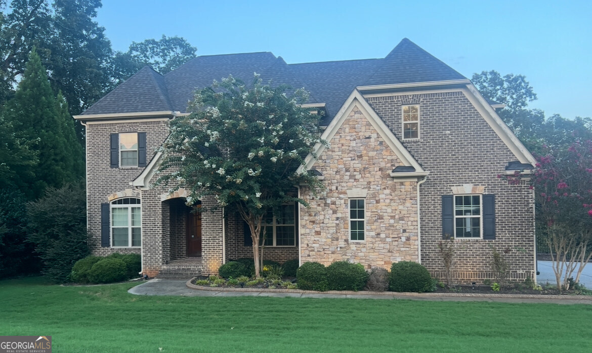 Welcome home! Discover refined Southern living at this stunning custom residence built by Colombo Homes. Tucked away in the serene River Walk community of Douglasville, this 2014 build was thoughtfully designed with comfort, space, and style in mind. This 5-bedroom, 5-bathroom home offers elegant living on nearly an acre of beautifully manicured land. From the moment you arrive, the home's curb appeal is undeniable. A covered front porch welcomes you into a grand two-story foyer, where natural light floods the open layout. Soaring ceilings, timeless trim details, hardwood flooring and designer finishes create a sense of quiet luxury throughout. At the heart of the home is a chef's kitchen outfitted with custom distressed 42" cabinets, granite countertops, tile backsplash, stainless steel appliances, and a generous center island perfect for gathering. The kitchen flows seamlessly into the breakfast area and the inviting family room with custom built-ins, and offering a fireplace for a cozy retreat. Rounding out the first floor is the formal living/dining rooms, and private office. Upstairs, The private primary suite is a peaceful haven, complete with a tray ceiling, spa-inspired bathroom, and an oversized custom walk-in closet. you'll find three additional bedrooms, two full bathrooms, and a spacious media room that can easily serve as an additional bedroom, home theater, playroom, or office. Step outside to the back patio overlooking a backyard with tranquil views -ideal for morning coffee or evening gatherings. The fully finished basement offers an additional bedroom, full bath, wet bar, and additional flex spaces. The backyard features a rear porch, and plenty of green space for gardening or play. Additional features include a spacious three-car garage, professional landscaping with irrigation(front/back), and ample storage throughout. Located in a quiet, upscale neighborhood with sidewalks and street lights. Schedule your private showing today and see what makes this home truly special. Happy Showing!