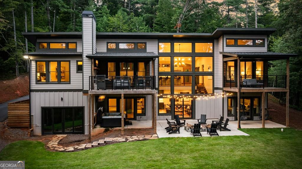 Custom mountain-modern home featuring an indoor heated pool, 5 bedrooms, 5.5 bathrooms, and 4,237 square feet of luxurious living space. This stunning property offers 3 king master suites (including two on the main level), a fourth bedroom with two full beds and ensuite bath, and a fifth bedroom with a full-over-full custom bunk and an XL twin-over-twin custom bunk, also with an ensuite bath. The modern kitchen boasts a breakfast bar and opens to a large dining area, while all bathrooms showcase beautiful custom tile work. Designed for comfort and entertaining, the home features 3 gas fireplaces plus an outdoor fire pit, two large covered decks, a top-of-the-line 6-person hot tub, multiple gathering areas, a downstairs bar, a game room with ping pong, and more. Enjoy a private hiking trail and community creek access with catch-and-release trout fishing in the desirable Watersong community, all just 10 minutes to downtown Ellijay and 25 minutes to Blue Ridge. All paved access! Outdoor enthusiasts will love the proximity to some of the best mountain biking trails in the Southeast, with Bear Creek and Pinhoti Trailheads only 4.6 miles away. Fiber internet! Fully furnished, turnkey, just bring your toothbrush!