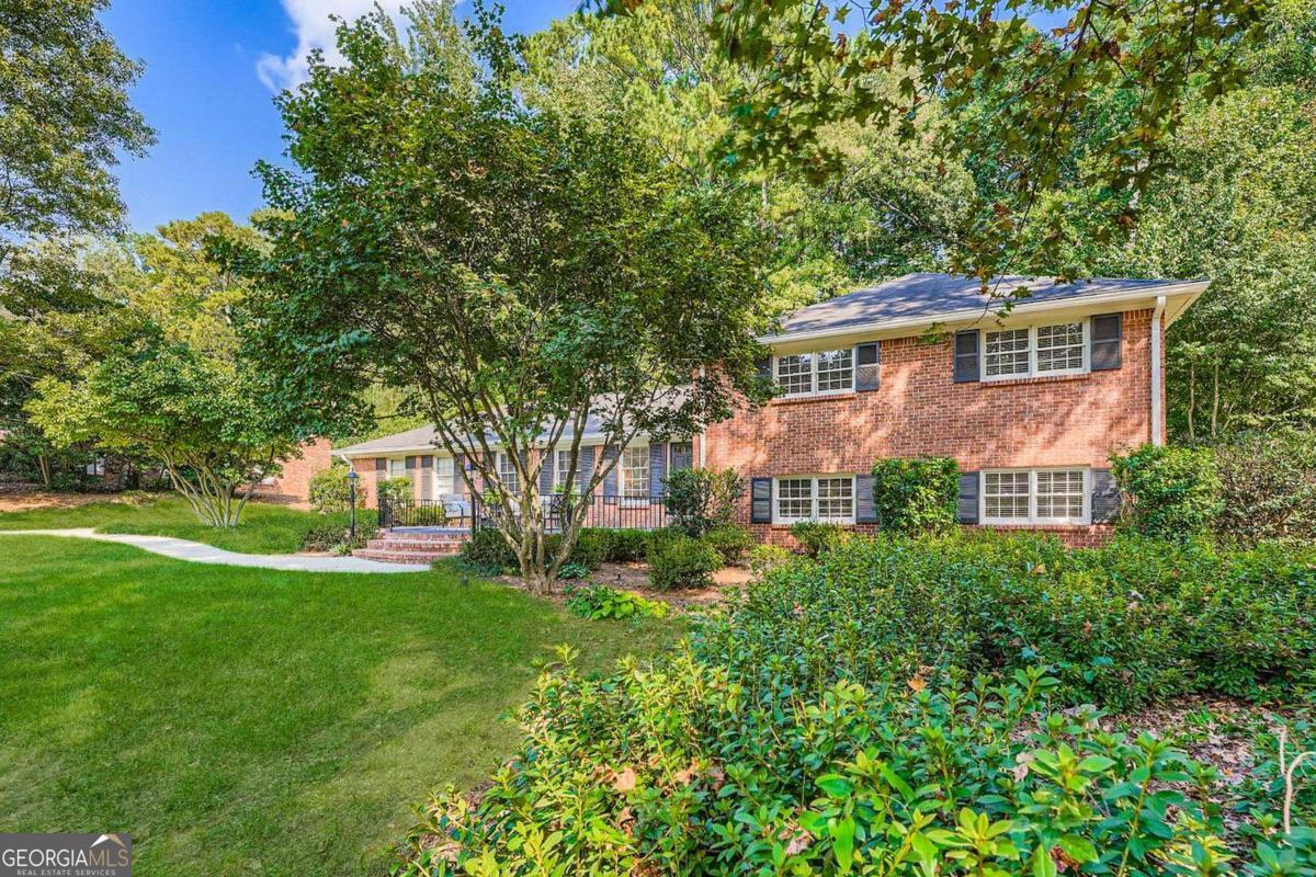This stunning 5-bedroom, 3-bath brick split-level traditional home boasts excellent curb appeal, a professionally installed irrigation system, and a welcoming front patio. Situated in the highly sought-after Briarlake Elementary and Lakeside High School district, it offers the perfect blend of style, comfort, and convenience. As you step inside, you're greeted by a light-filled interior with beautiful hardwood floors on the main and upper levels. The oversized main-level family room is filled with natural light, creating a warm and inviting space to relax or entertain. The white eat-in kitchen showcases a designer backsplash, stainless steel appliances, granite counters, and a spacious pantry. The dining room, complete with a fireplace, opens through French doors to a back patio-the perfect setting for cozy dinners and gatherings. Upstairs, the serene primary suite features a completely renovated bath (2018) with double vanities, quartz counters, an oversized walk-in shower, and elegant marble tile flooring. A second updated bath serves two additional bedrooms on this level. The lower level provides even more living space, with two additional bedrooms, a full bath, a large laundry room, and a second family room ideal for relaxation or entertainment. Ample storage includes two attics and a garage storage room with shelving and a workbench. Recent upgrades include new AC systems (2021 and 2023), ensuring year-round comfort. Outside, the private, flat backyard offers a charming patio for grilling and entertaining, along with a tranquil path leading to a secluded area ideal for a dog run or garden. Conveniently located just half a mile from Briarlake Forest Park and only minutes from Emory, CDC, and CHOA, this home provides both natural beauty and modern convenience. Don't miss the opportunity to make it yours today.