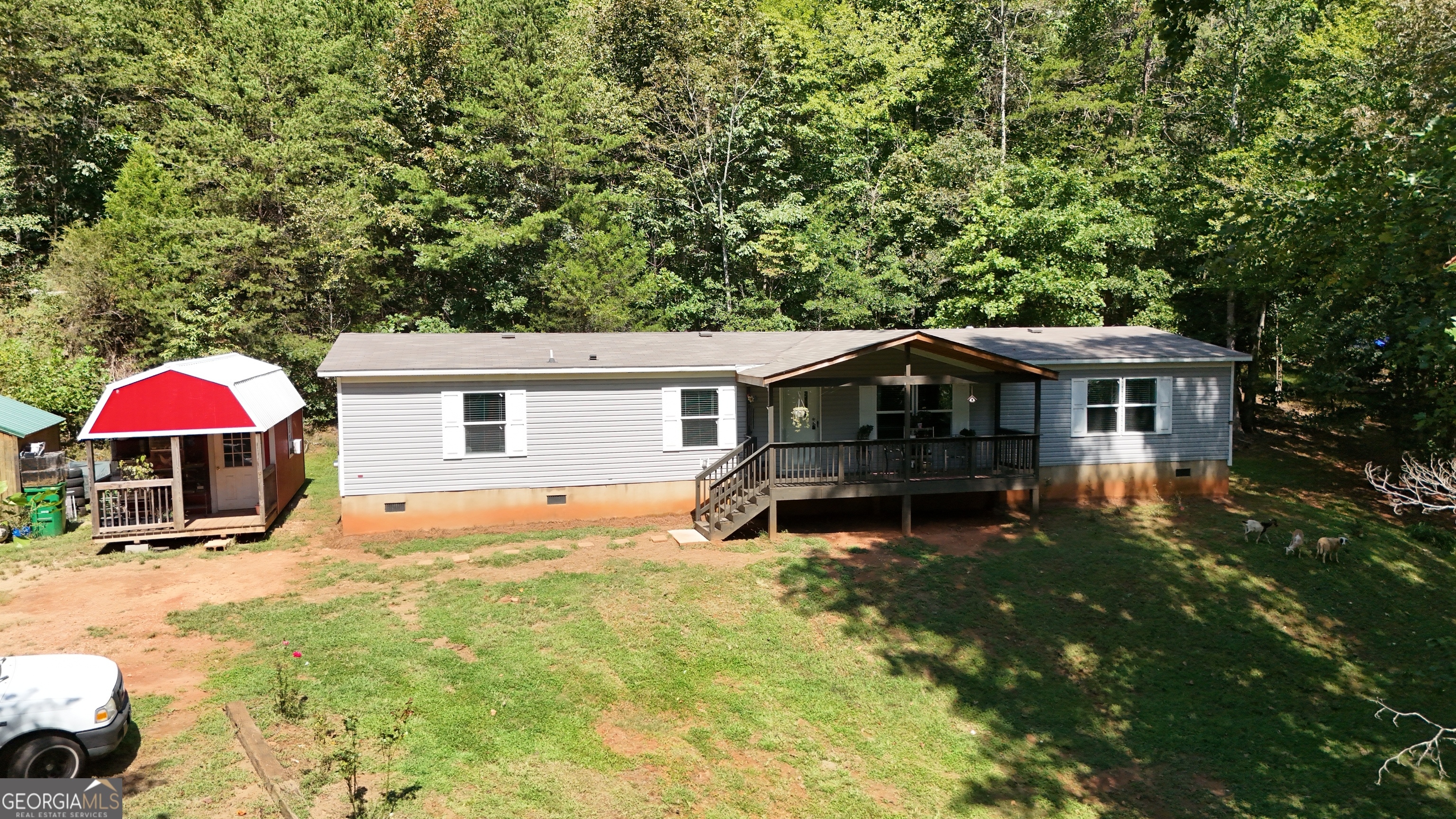 Discover the freedom of country living with this private, unrestricted property in beautiful North Georgia. Perfect for animals, chickens, and gardening, this property offers endless possibilities with no CCRs or HOA restrictions. A flowing creek runs along the property line, adding both charm and natural beauty. The 2023 mobile home features 4 spacious bedrooms, 2 full baths, an open floor plan with both a living room and den, and a large kitchen with island-ideal for family gatherings and entertaining. Enjoy peaceful mornings on the rocking chair front porch or host cookouts on the covered back deck. The outdoor space is perfect for kids to play and explore. Conveniently located in Clarkesville, GA, this hard-to-find property is perfect for a large or growing family looking for space, privacy, and the freedom to live how they choose.