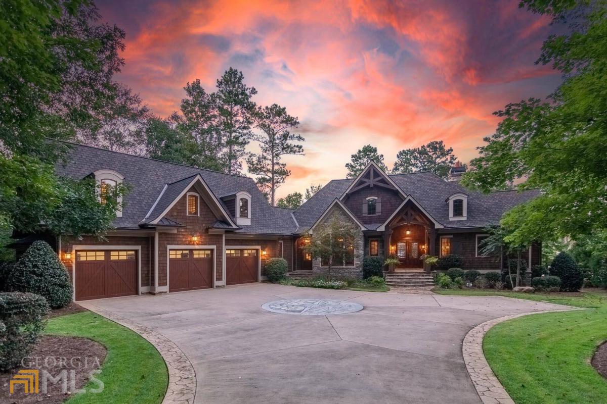 "INCREDIBLE LAKEFRONT HOME IN REYNOLDS LAKE OCONEE BUILT FOR THE OUTDOOR LIVING LIFESTYLE" Whether you are entertaining a large crowd or simply enjoying a quiet moment poolside, this lakefront home was built with rustic elegance and quality craftsmanship, with an open floor plan designed for family entertaining. The 5,800 +sq ft 4-bedroom, 4.5 bath home features an abundance of outdoor living space with over 2,000 sq ft of outdoor porches built with heaters and retractable glass doors to bring the outside in.The home features a lakeside pool with fire bowls,cascading water feature, outdoor cabana with kitchen, private max dock, and plenty of space to relax and enjoy Lake Oconee. The craftsman style house elevates you into a lake lodge style atmosphere with open floor plan, walnut flooring, beautiful beamed ceilings in the living room, large kitchen with Viking refrigerator, double ovens, warming drawer and pot warmer. The main level living area features retractable sliding doors to truly bring in the outdoors where you can enjoy the screen porch year round with in-ceiling heaters and stone fireplace. The main floor includes the spacious master bedroom, office with large windows, walk-in pantry, laundry room, stairs leading to the large bedroom suite over the garage with full bath, bar area with mini-refrigerator, microwave and sink. The terrace level features travertine flooring with walnut inlay, two bedroom suites with two full baths (one bathroom connects to the pool area and outdoor shower), wine cellar. The downstairs entertainment area is second-to-none with a banquette booth seating area, large projector and screen, and a spacious bar with dishwasher, refrigerator, freezer, and ice maker. The bar area has large slider windows that open for poolside counter service. The terrace level also has a set of retractable doors that open up the living area to a wide porch with plenty of space to gather, and a heated pool and spa. Also enjoy the poolside gazebo with built-in gas grill, two Green Egg smokers, and TV hookup. House is served by a Control 4 system for automated audio, video, climate control, lighting and security. Other features include indoor/outdoor speaker system, outdoor lighting system spanning from driveway entrance to max dock area. Membership is available for buyer to enjoy all the amenities. Ideally located within boating minutes to the Lake Club, Ritz Carlton and all the fantastic amenities of Reynolds Lake Oconee.