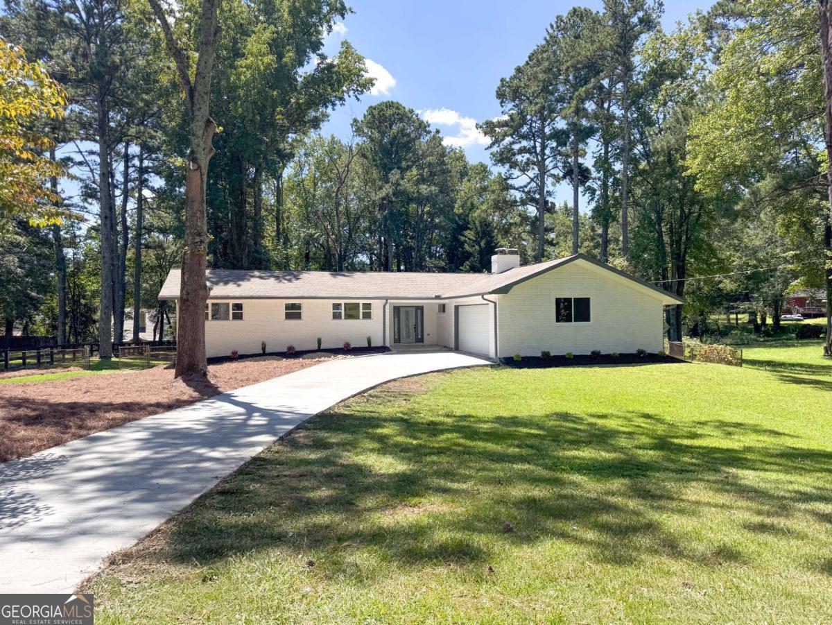 Fully Renovated Marietta Home with Finished Basement and Spacious Backyard. Step into this beautifully renovated home in the heart of Marietta, where modern design meets everyday comfort. The open concept floor plan fills the home with natural light and features a gourmet kitchen with quartz countertops, stylish backsplash, new cabinets, and Samsung stainless appliances, perfect for cooking and entertaining. With 4 spacious bedrooms and 2 fully updated bathrooms, every detail shines, from elegant tile finishes to brand-new flooring throughout. The finished basement offers endless possibilities, create a game room, home theater, or even a private suite. Plus, it includes a second garage with direct access to the backyard. Enjoy the outdoors in your expansive, level backyard with lush green lawn, ideal for pets, gatherings, or quiet mornings. Recent upgrades also include a new driveway, garage doors, windows, HVAC, plumbing, and electrical systems, making this home truly move-in ready. All this in a prime location, just 5 minutes from Wheeler High School, top-rated in the area, as well as shopping, dining, and conveniences.