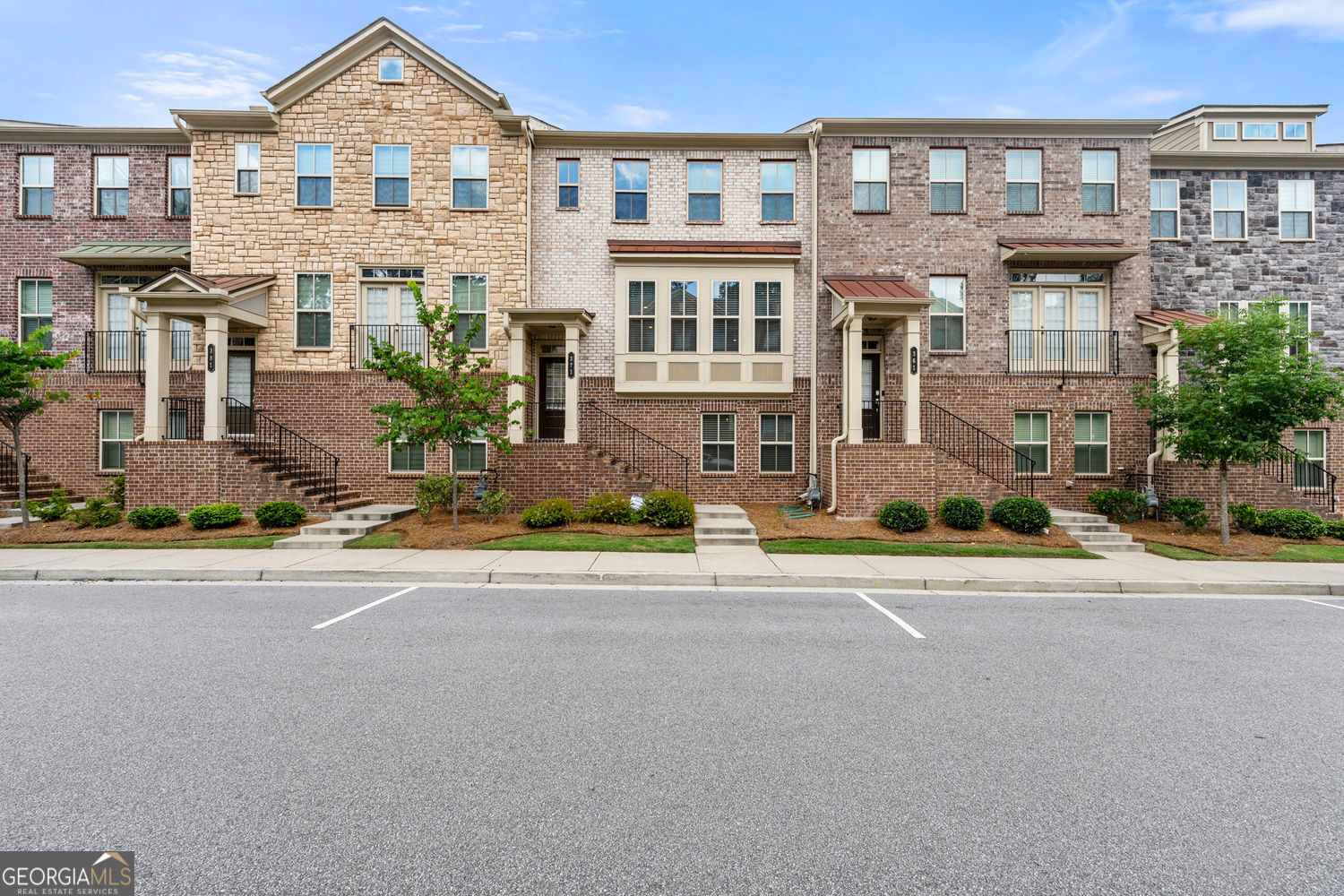 Modern Luxury in the Heart of Suwanee! Welcome to this stunning, move-in-ready 3-level townhome just 2miles from Suwanee Town Center, where you'll enjoy restaurants, shops, concerts, and community events year-round. Zoned for the top-rated North Gwinnett High School District, this 4-bedroom, 3.5-bath gem was built in 2020 and showcases tasteful interior design, rich hardwood floors, and high-end finishes throughout. Step inside to discover Soaring Ceiling & Open Living Spaces anchored by a cozy fireplace and filled with natural light. The Chef's Kitchen is a true showstopper with double built-in wall ovens, a 5- burner gas cooktop, walk-in pantry, tile backsplash, and an oversized island that flows seamlessly onto your private deck - ideal for morning coffee or sunset entertaining. Upstairs, the Private Owner's Suite offers a spa-like bath with dual vanities and a custom California Closet, plus two additional bedrooms, a full guest bath, and a perfectly placed laundry room. The terrace level features a Versatile Fourth Bedroom & Full Bath, ideal for guests, an offic?, or in-law space. This low-maintenance, Four-Sided Brick Townhome also includes professional landscaping, sidewalks, and streetlights, with quick highway access for easy commuting. Seller's furniture is negotiable with the sale, adding extra value for a truly turnkey move. Plus, buyers may qualify to assume the seller's current low-rate loan, creating a rare opportunity to save thousands. Don't miss your chance to own this beautifully designed townhome in one of Suwanee's most desirable communities - schedule your showing today!