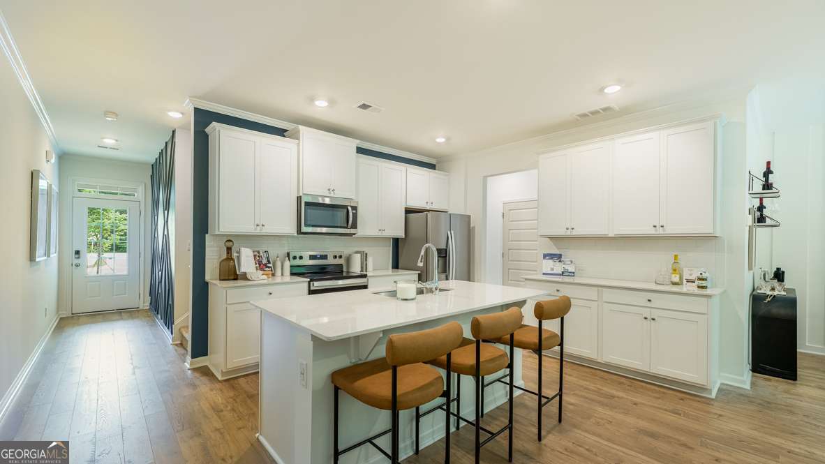 Welcome home to Stratford floorplan, a stunning new construction townhome that effortlessly blends comfort, style and generous living space. From the moment you step inside, you're welcomed by an open layout that feels both spacious and inviting. The main level centers around a beautifully designed kitchen with 42 inch cabinets, a large island that doubles as a gathering spot, quartz countertops, crown molding, and a sleek tile backsplash. The kitchen flows naturally into a light-filled living area and a dining space that's perfect for hosting or simply relaxing at home. Upstairs, two secondary bedrooms share a well-appointed Jack and Jill bathroom and each feature their own walk-in closet, offering plenty of storage and privacy. The primary suite is tucked away for added peace and quiet, complete with a spacious walk-in closet and a private en-suite bath. With upscale finishes throughout, generous closet space, and a low-maintenance exterior, this unit lives like a single-family home and is ideally located near parks, shopping, and dining along Barrett Parkway.