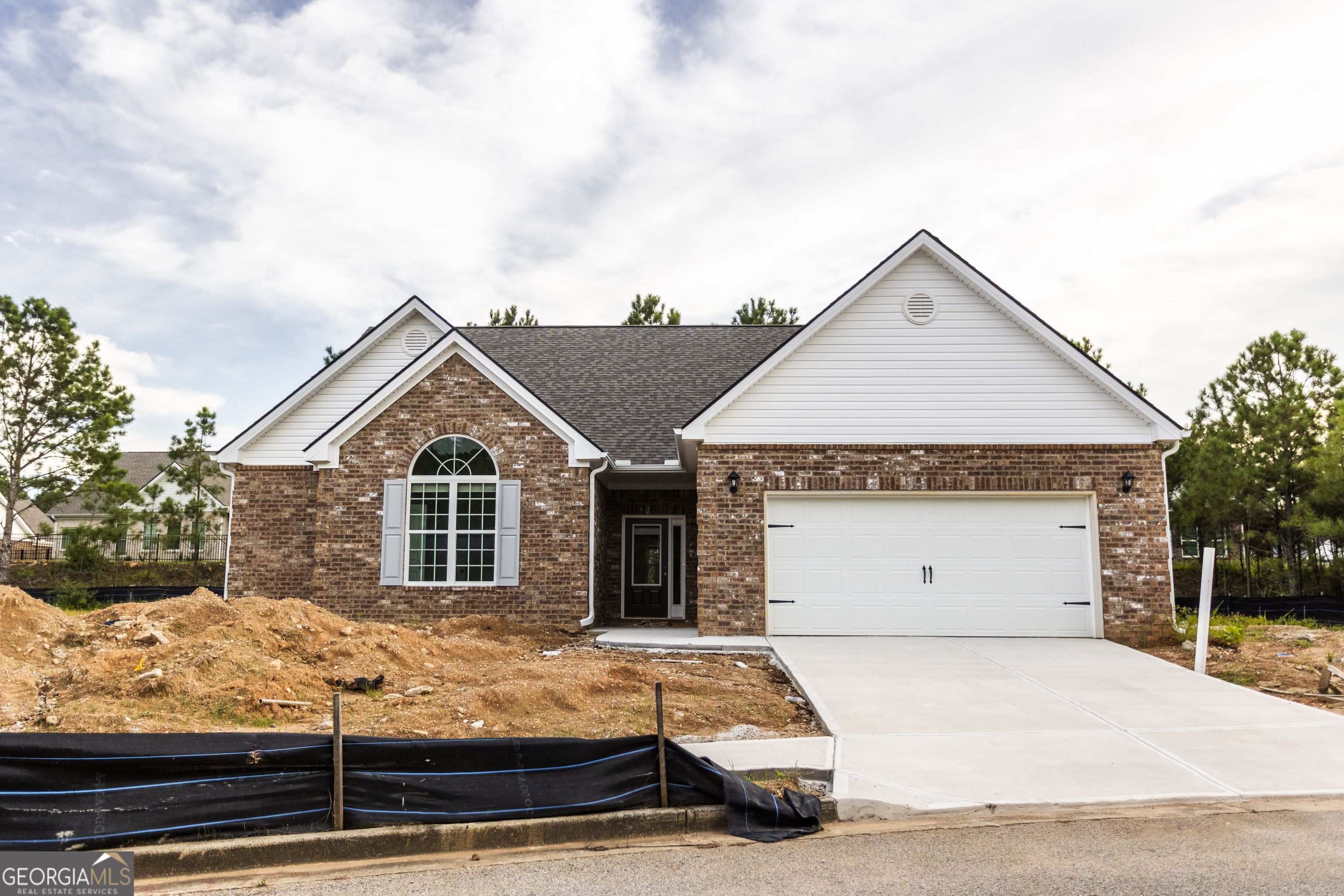 Discover low-maintenance living in this beautifully designed all one-level, four-side brick home! This thoughtfully planned residence offers handicap accessible doorways throughout, making it both comfortable and convenient for every stage of life. Step inside to find an open, bright kitchen featuring granite countertops, stainless steel appliances, a breakfast bar, pantry, and plenty of cabinets-perfect for everyday living and entertaining. A separate dining room provides space for gatherings, while the sunroom offers a relaxing retreat filled with natural light. The spacious master suite is complemented by a private bathroom with abundant closet space. The home also includes two additional bedrooms and a powder room for guests. Flooring features luxury vinyl tile throughout the living areas with carpet in bedrooms for added comfort. The living room centers around a cozy gas fireplace. Enjoy maintenance-free living with the HOA maintaining the lawn, giving you more time to take advantage of the community clubhouse, fitness center, and sidewalks. The community is just a short walk or golf cart ride to shopping and restaurants of Downtown Social Circle!