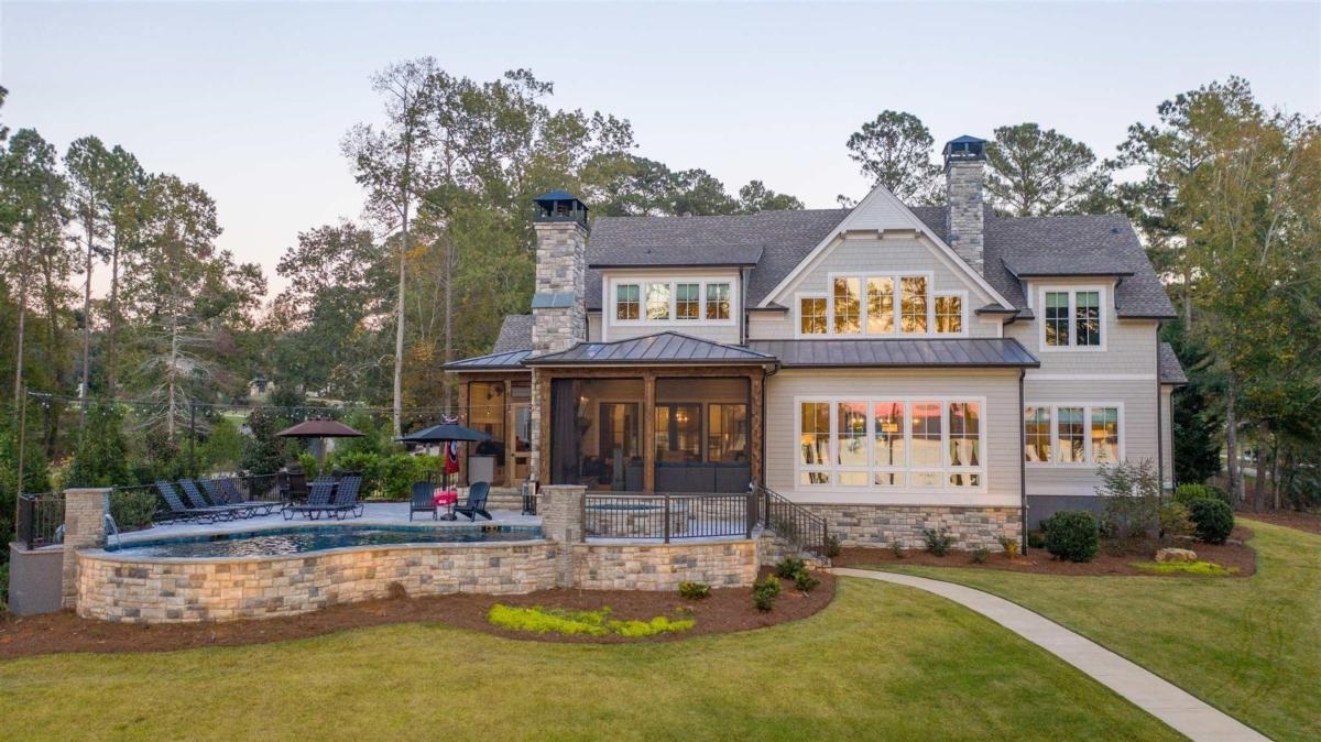 Custom Lakefront Home with Beautiful Sunset Views, located in The Landing @ Reynolds Lake Oconee and Built in 2019. From the Minute you walk up to the Front Door, you can see Lake Oconee. This 5 Bedroom, 5.5 Bath Home sits on a Professionally Landscaped Level Lakefront Lot with Huge Main Water Views and a Vinyl Max Dock. Custom Upgrades throughout Entire Home including Wolf and SubZero Appliances, Custom Cabinets, Quartz Countertops, Pella Windows/Doors, Two-Story Foyer/Living Room Ceilings, Full Stacked Stone Fireplace, Exposed Wood Beams, Hickory Wood Flooring, Shiplap Foyer, Custom Iron Railing, Butler's Pantry, Wine Room and Genesis Home Elevator. Screen Porch with Full Stacked Stone Fireplace, Tile Floors, Electric Retractable Screens and Electric Retractable Vinyl Enclosures. Outdoor Kitchen with Custom Cabinets, Quartz Countertop, Sink, Built-in Wolf Gas Grill, Built-in Komado Joe Ceramic Grill and Stainless Gas Burner/Griddle. The Heated Pool, Hot Tub and Travertine Patio are Perfect for entertaining Family and Friends. Whole Home Integration System with WiFi Control of HVAC, Audio System, Pool/Hot Tub, Garage Doors, Security System and Exterior Surveillance Cameras. Encapsulated Crawlspace with Commercial Dehumidifier. Move-in Ready for Summer Fun.
