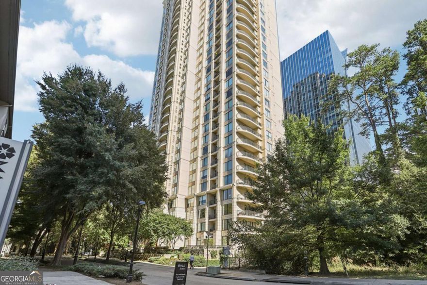 PREMIER LUXURY HI-RISE IN BUCKHEAD! Experience luxury living at The Paramount, one of the most sought-after addresses in Atlanta. Enjoy the breathtaking city and sunset views from the 21st floor. This unit offers a spacious one-bedroom, one-bathroom layout, with an additional room providing the flexibility to be used as a separate dining room, den, or office - perfect for working from home or creating a cozy space to unwind. As you enter, beautiful hardwood floors and large picture windows create a warm and inviting ambiance. The spacious open living/dining area, with motorized shades, is flooded with natural light and has access to the oversized private balcony, ideal for both entertaining and relaxation Enjoy cooking your favorites meals in the modern galley kitchen boasting sleek quartz countertops, ample cabinetry, built in wine rack and stainless steel appliances. The generously sized primary bedroom offers both comfort and privacy, with a walk-in closet for ample storage. The adjacent spacious bathroom features double vanities, a large soaking tub with shower quartz countertops and tile floors. The dedicated laundry area is roomy and adds additional storage space. This unit also includes one assigned closed garage with plenty of room for storage. The Paramount at Buckhead offers exceptional amenities including a 24/7 concierge, guest parking, large pool with towel service, cabanas, tennis court, indoor and outdoor theaters, grilling area, fire pit, fitness center, complimentary coffee bar, wine lockers, business center and more! Located in the heart of the Buckhead financial center, with it is easy access to upscale restaurants, Phiipps Plaza and just steps to MARTA, Peachtree Road and more. It is a prime location, with direct access to Highway 400 via private access through Alliance Center to avoid multiple traffic lights. Enjoy the ideal combination of luxury, convenience, and location at The Paramount. Don't miss out on the opportunity to make this your next home!