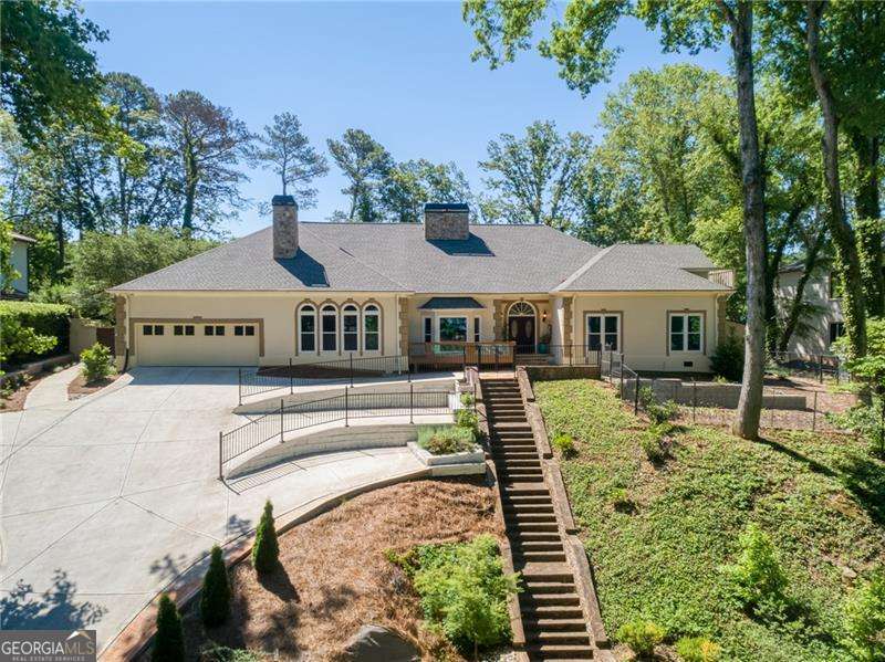 Tucked in Atlanta Country Club's quiet interior, this stately renovation on an amazing golf course lot w/pool overlooks the 8th fairway. The ideal layout features double primary suites (w/3 total bedroom suites on the main) and 2 additional gabled bedrooms upstairs, including a fully-equipped Au Pair Suite. Boasting loads of well-designed space with carefully curated owner renovations, this desirable hilltop front presence and restful backyard perch above the golf course greens is a must to experience. The grand flagstone entry leads to an expansive great room w/soaring ceilings and a stunning floor-to-ceiling double sided stone fireplace, all bathed in natural light, grounded in rich hardwoods, and boasting views of the private pool surrounded by foliage and 150' of golf course backdrop. A spacious fireside Owner's Suite includes an entry enclave ideal for an office or reading nook, French Door pool terrace access, and a refreshing spa-like bath with solid stone vanities, a rolling shower enclosure, jetted soaking tub, and a truly endless walk-in closet. Left of the great room is a working chef's kitchen boasting oversized quartzite island w/seating, 48" Viking Range and Microwave, Samsung Bespoke Refrigeration, a separate Wine Cooler, and a Custom Serving Hatch, all seamlessly flanked in front by a sun-drenched living room with marble floors and a stone fireplace, and in back by an oversized dining room with a graceful view of the lush pool deck. 5 French Doors lead from the great room, dining room and main floor bedrooms to an expansive flagstone terrace, intimate gunite pool, bridge, and screened gazebo - all enveloping the senses in a resort-like outdoor oasis on the newly renovated ACC golf course. Landscaped for the ultimate in privacy, integrated w/gas for grilling, and fully-fenced, the home's back is spectacular and well-equipped. In front, a 2 car garage and tiered motor court make for easy hosting. Upstairs features a balconied Au Pair Suite with second laundry, kitchen, great room, 1 1/2 baths and 2 additional flex rooms. The second balconied bedroom sits on the opposite side of the home, ideal as a private retreat. The basement rec room / teen suite has an ensuite bath and French door access to the back yard. This naturally cool getaway space is not included in the bedroom count. Ideally situated with easy access I-75, GA-400, and the heart of East Cobb with upscale restaurants, shopping, sports leagues, Truist Park and The Battery, Marietta Square, Roswell Square and Sandy Springs City Center. Live the Country Club life, or simply enjoy all that this lovely community and award-winning school district have to offer.