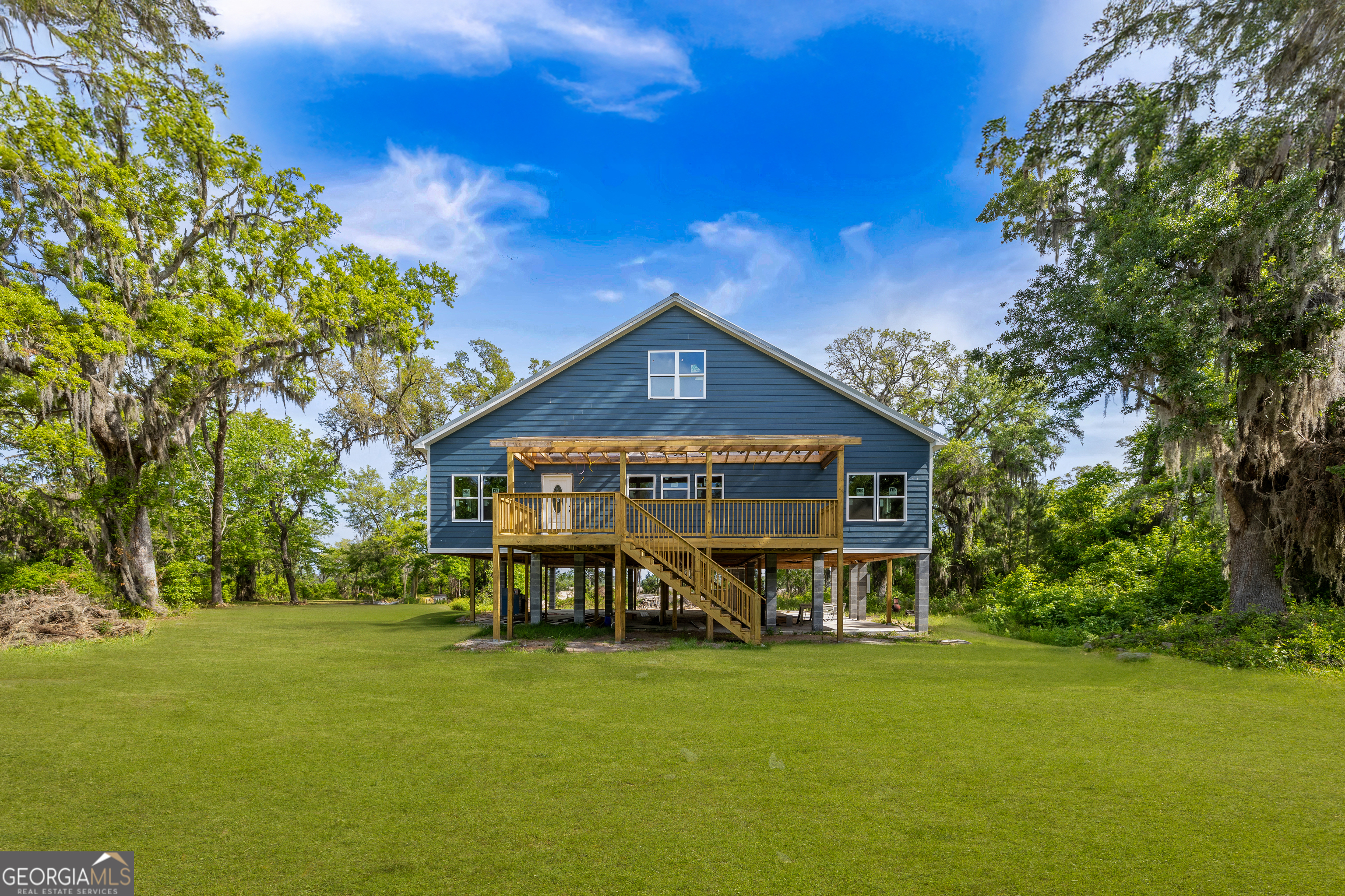 Bring your vision to life with this unique opportunity to finish a custom marshfront home on nearly 4 acres! The current layout offers 5 bedrooms & 4.5 baths with 10' ceilings, tons of windows, and two-rear facing suites to capture stunning marsh views. The kitchen spans an impressive 19 feet wide and includes a convenient pantry. The third floor has been thoughtfully designed to be a 1,200 SF in-law apartment with its own kitchen, laundry, and accessible from the custom Galaxy platform lift & via a separate staircase inside. Double 72" patio doors perfectfully spotlight the water views and flood the space with natural light. Elevated on 9' piers for piece of mind, this home is built with lasting quality in mind including Hardie board siding & a durable metal roof. You'll also enjoy the convenience of covered parking on both sides of the home as well as ample workshop/storage space below. Don't miss this rare chance to make your dreams of coastal living a reality!