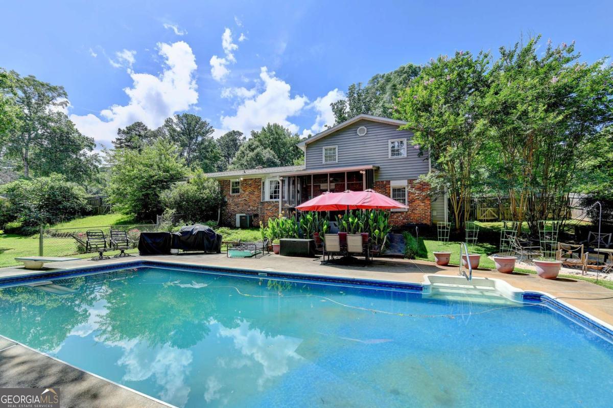 Charming Home with In-Ground Saltwater Pool in Parkview School District! Nestled in the highly sought-after Parkview School district, this well-built 3-bedroom, 2-bath home offers a perfect blend of comfort, function, and outdoor enjoyment. Step inside to find a formal dining room, a cozy family room with a fireplace, and an additional versatile space ideal for a pool table, reading nook, or game area. The eat-in kitchen, conveniently accessed from the brand-new driveway, overlooks the inviting family room creating a seamless flow for everyday living and entertaining. Step outside to the showstopping screened-in porch, the perfect spot for morning coffee or evening gatherings, all while enjoying views of the fire pit area and sparkling in-ground pool. The private, beautifully landscaped backyard is a true retreat, complete with fruit trees, a garden area, and lush greenery. Whether you're hosting summer pool parties or relaxing under the stars, this outdoor space is ready to impress. Don't miss your chance to own this gem in one of Gwinnett's premier school districts! Welcome Home... The Good Life Awaits!