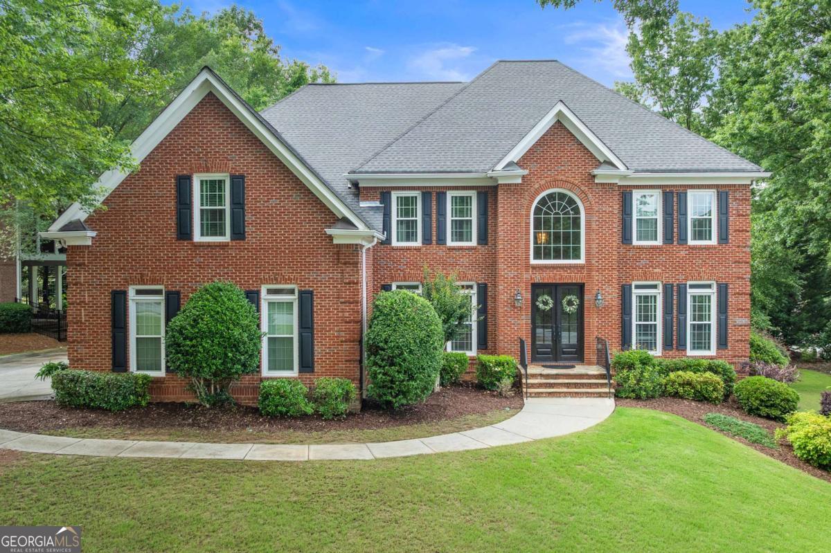 Welcome to this exceptional 6-bedroom, 6-bathroom brick home located in a highly sought-after Alpharetta swim/tennis community. Perfectly situated on a private, wooded corner lot, this property offers timeless curb appeal and a long list of impressive upgrades that set it apart. Step into the soaring 2-story foyer where gleaming hardwood floors and abundant natural light create a warm and elegant welcome. The main level features a formal living room and dining room, ideal for hosting gatherings, while the 2-story family room boasts a dramatic wall of windows, a cozy brick fireplace, and an open, airy feel. The chef's kitchen is beautifully designed with a large center island, white cabinetry, quartz countertops, stainless steel appliances, gas range, built-in wine rack, and a sunny eat-in breakfast area. A convenient guest suite is also located on the main level. Upstairs, retreat to the luxurious primary suite complete with vaulted ceilings, a fireplace, and a tranquil sitting area. The spa-like ensuite bathroom features double vanities, a soaking tub, a separate glass walk-in shower, and a massive walk-in closet. Spacious secondary bedrooms offer comfort and flexibility for any lifestyle. The finished terrace level is a true extension of the home, offering a full bar, game room, exercise room, bedroom, and full bath-perfect for entertaining or multi-generational living. Step outside to a screened-in porch and Trex deck, ideal for grilling and enjoying the beautifully landscaped backyard with turf lawn and private wooded views. Extensive updates include 26 new windows (2019), basement flooring and carpet (2020), Trex deck and porch (2016), backyard turf (2019), two new furnaces and AC units (2024), refrigerator, two water heaters (2022), and Dog Watch electric fence (2021). The roof was replaced in 2010. Enjoy resort-style neighborhood amenities including a pool, tennis and pickleball courts, clubhouse, playground, community dock, fishing lake, and business center. Zoned for top-rated schools and just minutes from shopping, dining, parks, and major commuter routes, this stunning home offers the perfect blend of luxury, space, and location. Don't miss this rare opportunity!