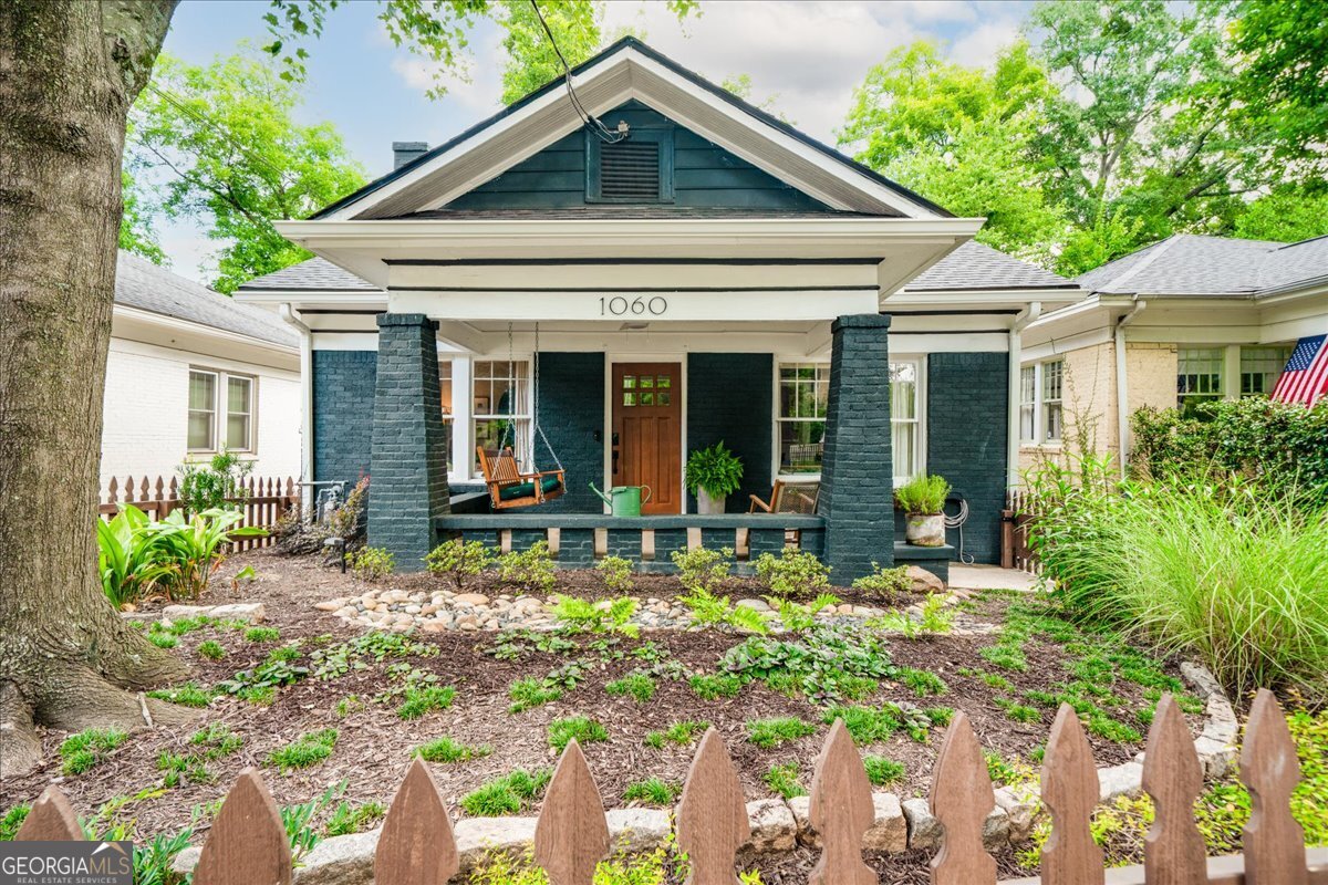 This beautifully preserved 1928 bungalow offers the perfect blend of historic character and modern updates, ideally located between East Atlanta Village and Glenwood Park and just a five-minute walk and two-minute bike ride to the BeltLine. This fully-renovated, custom designed home features high ceilings, high-end tile and wallpaper, and a recently redesigned galley kitchen with a gas stove and vent hood. The primary suite includes a renovated bathroom with a soaking tub, spacious walk-in shower, and easy access to washer and dryer. With classic picket fencing, thoughtful landscaping, and fully fenced front and back yards, this home invites you to enjoy outdoor living from both porches. Features off-street parking and a large, unfinished basement with interior access and freezer-perfect for storing bikes, tools, or seasonal items. A generous primary bedroom anchors the home, while the flexible second bedroom works beautifully as a guest room, office, or added living space. Designed for entertaining, this home has hosted everything from backyard garden parties to a full wedding. Whether relaxing at home or exploring nearby neighborhoods, 1060 Glenwood offers comfort, character, and a location that balances charm with city convenience.