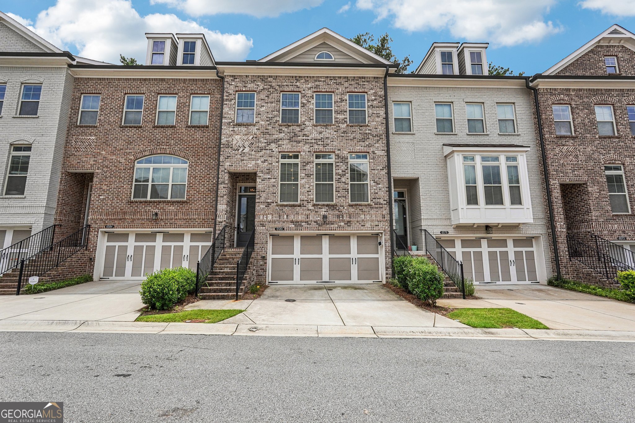 Like new, North facing townhome from The Providence Group. The largest floor plan (Foster C) with over $20K in builder upgrades. Spacious open living with private wooded backyard! Main floor highlights great room with gas fireplace, dining area, elegant kitchen with upgraded white cabinets, stainless steel appliances, bespoke refrigerator, Cambria counter tops, and island offers additional seating. All appliances convey. Upstairs 9' ceilings, primary suite with extensive walk-in closet, Carrera marble dual vanity, high frameless shower, garden tub. Two secondary rooms share full bath with laundry in the hall. Terrace level offers private guest ensuite with walkout to screened porch. Hardwood floors throughout, tiled baths, carpet in upper bedrooms only. Generous 2-car garage equipped with EV charger. Convenient to restaurants, shopping and top-rated schools! Enjoy the maintenance free life - HOA fee covers Exterior maintenance and roof, exterior grounds, Swim, Tennis, 2 Gates, Trash, Termite.