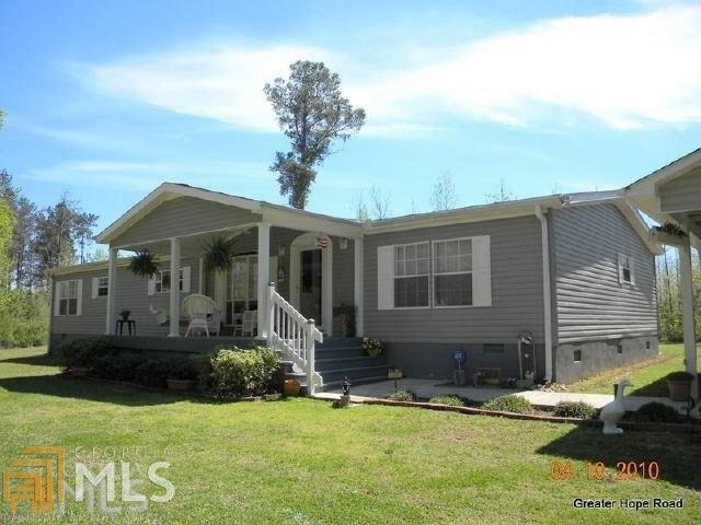 Excellent condition, move in ready. Large 2002 Custom Sunshine mfr home on permanent foundation. Favorable private wooded & level 3+ acre lot plus multiple out buildings. Paved access road w frontage. Private 400ft+ deep water well. Custom matching carport & two out buildings. No HOA or S/D restrictions. Home warranty available at cost.