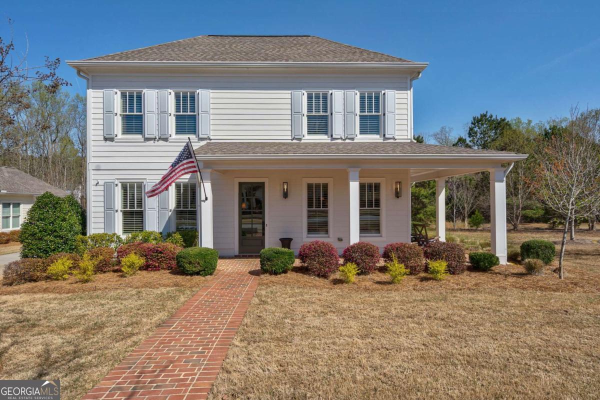 Welcome to 2970 Greenleffe Drive, a picture-perfect Southern charmer nestled in the sought-after Charleston Park neighborhood of The Georgia Club. This beautifully renovated 3-bedroom, 3.5-bathroom home offers 2,380 square feet of thoughtfully curated living space. With timeless curb appeal, a brick walkway, and a wide covered front porch, this home radiates true Southern hospitality. The porch, featuring brick flooring, classic columns, and elegant lighting, offers the ideal setting for morning coffee or evening sunsets while overlooking the tranquil, private greenspace adjacent to the home. Inside, youre greeted by a stunning interior boasting hardwood floors, detailed millwork, and sophisticated finishes throughout. Whether hosting guests or enjoying everyday life, this home delivers the perfect balance of style, comfort, and connection. Step through the front door into a gracious entry hall that immediately sets the tone with its understated elegance. The warm wood flooring and soft neutral palette continue into the formal dining room, where an abundance of natural light streams through plantation-shuttered windows. Ideal for both intimate dinners and lively gatherings, the space offers a timeless layout that adds character just steps from the foyer. The kitchen is truly the heart of this home a beautifully designed space that encompasses both functionality and style. A large center island offers ample seating and storage, while custom milled floating shelves, crisp white custom cabinetry, and dramatic quartzite countertops that extend to the backsplash, elevate the overall aesthetic. A Kohler farmhouse sink and top-of-the-line Thermador stainless-steel appliances including a gas range and French door refrigerator ensure a premium culinary experience. Designer curated Visual Comfort lighting add the perfect finishing touches to the space. Open to the kitchen, the living room provides a relaxed yet sophisticated setting for everyday living or entertaining. Light drifts in, giving the space a bright and airy feel that accentuates the hardwood floors and crown molding. A cozy gas fireplace anchors the space, creating a welcoming focal point topped with a mantle ideal for artwork or a mounted TV. This open-concept layout fosters effortless flow and connection. The main-level primary suite is a true retreat, offering spacious comfort with refined touches. The spacious bedroom boasts stunning hardwood floors and is filled with natural light. The luxurious ensuite bath features dual vanities, a dedicated makeup station, sleek gold fixtures and Visual Comfort lighting. The oversized tiled shower includes both a rain shower head and a slider bar hand shower, and a built-in bench for added comfort. A generously sized walk-in closet with custom closet system connects directly to the laundry room, creating unmatched convenience. Upstairs, two additional bedrooms and a loft space provide flexibility for guests, family, and home office needs. One bedroom includes its own en-suite bath, while a second full bathroom is easily accessed from the hallway. Each space is designed for comfort and practicality, with tasteful finishes and ample storage. Outside, a private courtyard awaits complete with a covered patio, easy-care turf grass, and a beautifully lit privacy wall. This inviting space is perfect for outdoor dining, entertaining, or simply relaxing. Ceiling fans and Visual Comfort sconces enhance both comfort and ambiance, while direct access to the oversized two-car garage adds ease to everyday living. Dont miss the opportunity to call 2970 Greenleffe Drive home. With its thoughtful design, luxurious details, and prime location in The Georgia Club, this Southern beauty offers a lifestyle of elegance, warmth, and ease.