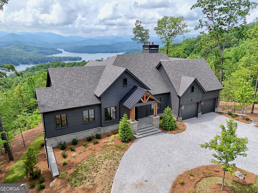 A masterpiece of modern luxury set amidst the highland serenity of Northeast Georgia and overlooking Lake Burton, 1572 Parker Hollifield Rd in Tiger stands as a rare architectural statement at 2,400 ft elevation. Completed in 2023, this 4,300 sq ft estate spans 1.17 acres and captures panoramic mountain views from nearly every room-an awe-inspiring backdrop for everyday living or an exceptional mountain escape. Each of the 5 meticulously designed bedrooms includes a private en-suite bath, enveloping guests in comfort and privacy. Striking floating staircases, expansive dual living areas, and seamless indoor-outdoor transitions set the stage for refined entertaining and quiet reflection alike. The gourmet kitchen is a culinary sanctuary with Wolf and Sub Zero appliances, custom cabinets, quartz countertops, dual dishwashers, and a Miele integrated espresso system. Overlooking majestic vistas, the heated terrace with its indoor/outdoor fireplace invites year-round al fresco gatherings. The great room offers sleek and sophisticated interiors with floor-to-ceiling walls of glass that frame epic  views of Lake Burton and the surrounding mountains and all outfitted with Hunter Douglas Smart Shades. The private third-floor office retreat includes a wet bar and sweeping views that elevate remote work to a tranquil luxury. Outdoors, professionally landscaped grounds feature an iron-fenced dog yard, custom fire-pit, and plenty of parking with a wraparound driveway and attached oversized 2 car garage. Smart home technologies and security with Starlink connectivity ensure modern convenience in this natural setting. This home isn't just built-it's curated! This home is conveniently located 1.8 miles from Murray Cove Rd public boat ramp on Lake Burton and 5.5 miles from the Anchorage Marina and a 25 minute drive back to Downtown Clayton. An extraordinary offering available only by private appointment. Your elevated mountain lifestyle begins here.
