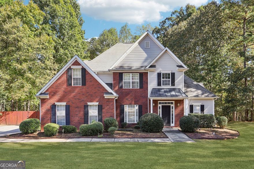 Step into this stunning 5 bedroom, 4 full bath home that beautifully blends modern luxury with timeless charm. Perfectly situated in a quiet, family-friendly neighborhood and just a short walk to the Fayette Pavilion-you'll have access to major retail shops, restaurants, and Publix for all your daily conveniences. Inside, the open floor plan offers exceptional flow and functionality. The chef-inspired kitchen opens to a spacious dinette area and cozy family room, complete with a double-sided fireplace that also enhances the elegant sitting room. A formal dining room provides the ideal space for gatherings. The luxurious master suite on the main level is a true retreat, featuring a Jacuzzi tub, separate shower, double vanity, and a walk-in closet. A second main-level bedroom and full bath offer flexibility for guests or multigenerational living. Upstairs, you'll find three additional bedrooms and two full baths, including a convenient Jack-and-Jill layout. The exterior boasts a low-maintenance brick front, 2-car side-entry garage, and a spacious private backyard. This home offers everything you've been searching for: space, comfort, and location-all within one of Fayette County's most desirable school districts.