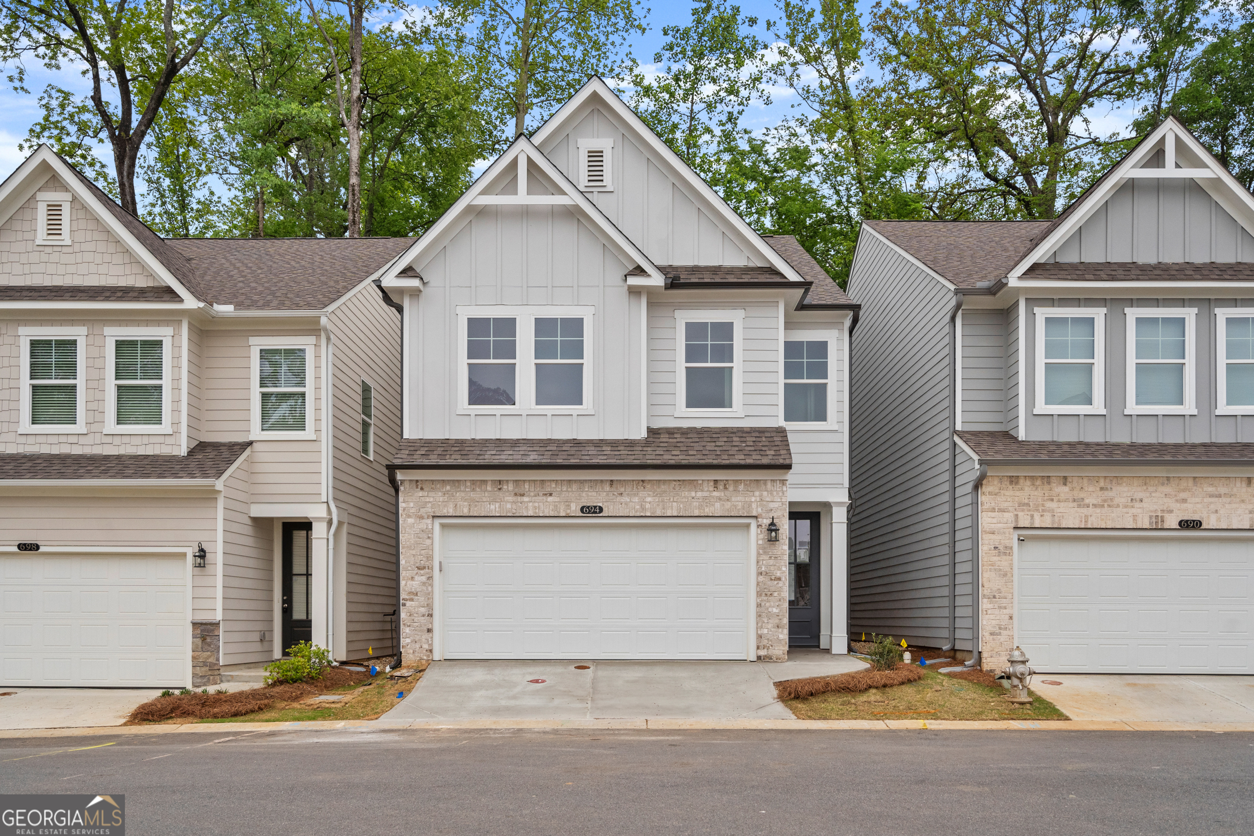 HURRY, FEW HOMES LEFT! Welcome to The Cary A lot 41, a stunning 3-bedroom, 2.5-bath residence in the sought-after GATED Village at Shallowford just steps from pool and clubhouse. This move-in-ready home spans 2,008 sq ft, combining elegance with practicality. The open layout invites you into a bright foyer leading to a gourmet kitchen with 10 FT island, 42" cabinets, gleaming granite countertops, and top-of-the-line stainless-steel appliances. Relax in the cozy living room, complete with a charming shiplap fireplace and 9 FT ceilings throughout the main level, or entertain guests in the adjoining dining room with easy access to the private patio. Retreat to the oversized primary suite, offering a luxurious extended tile shower and a walk-in closet, providing a peaceful escape from the secondary bedrooms. Enjoy the open railing staircase that adds a feeling of light and spaciousness and oak treads on the stairs enhance the sophisticated ambiance. Set within the ONLY gated community with a pool and clubhouse in Kennesaw, enjoy quality amenities and proximity to excellent schools. With its charming exteriors and open floor plans, this home is a true gem. Self guided tours available!