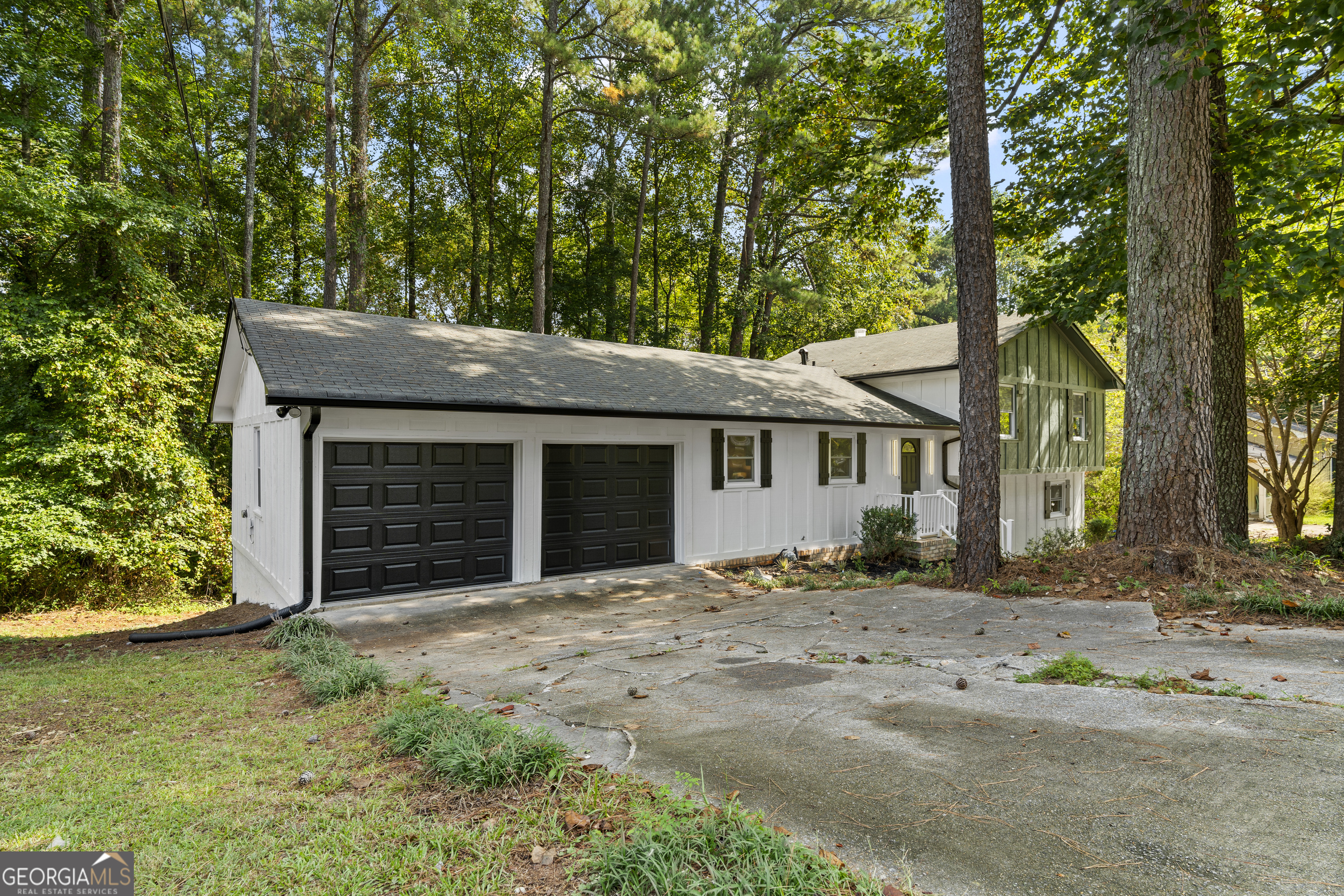 Updated split-level home in Lithonia. This 4-bedroom, 3-bath property offers a welcoming open-concept living space. The kitchen features an island with breakfast bar, white cabinets, tiled backsplash, stone countertops, stainless steel appliances, and stylish black hardware. The primary suite is bright and includes an ensuite bathroom with a new double vanity, tiled shower, and matching black hardware. The other bathrooms have been updated in a similar style. Additional highlights include a lower-level family room with fireplace, a two-car garage, and a rear deck perfect for relaxing or entertaining.