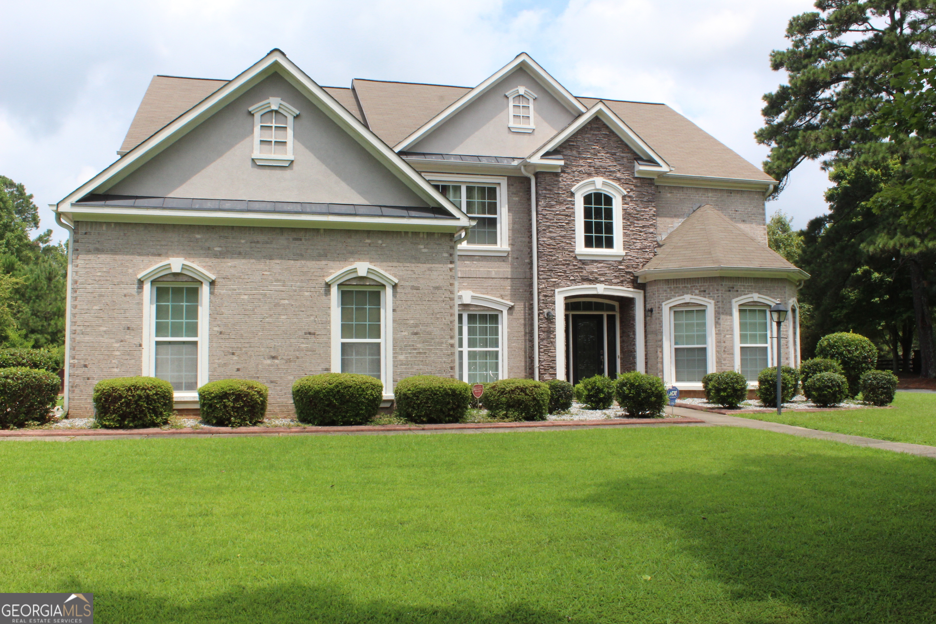 Welcome to 7553 The Lakes Drive. This home is in a prime location that combines the charm of suburban living with the convenience of easy access to the city. Gorgeous 3 sided brick home conveniently located in upscale neighborhood just about 16 minutes from the Hartsfield Jackson Airport. This home makes gracious first impression, from the curb appeal to the striking high ceiling to the gleaming hardwood floors. This home boasts 3 cars garage, two story ceiling in family room, massive kitchen overlooking family room with 42 inches cabinets, granite countertops, stainless steel appliances, double oven. Enjoy the beautiful arched doorways as you move around in the house plus tray ceilings. In master bath enjoy the oversized shower, jetted tub, separate vanities, his/her walk in closet. On the main floor spacious bedroom with walk in closet, full bath. Step outside and go for a walk in the subdivision and enjoy the lakes, tennis courts, basketball court, pool and playground area. With fenced backyard there is nothing to do but move in after closing, and welcome home again.