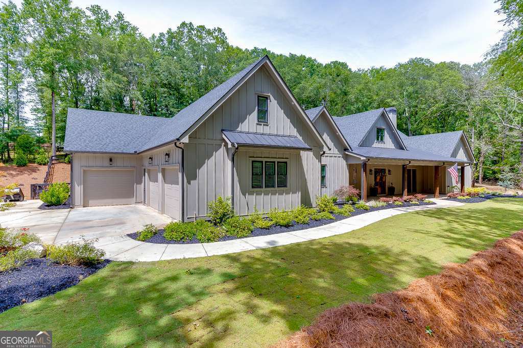 Welcome home to 1889 Jefferson River Road! This stunning 2-year-old custom sprawling ranch is nestled on 2.11 acres in beautiful Jefferson, GA. This 4 Bedroom, 3 Bathroom, and 2 Powder Room showstopper house has grand features and custom touches around every corner. Come in through the large front porch and double glass doors as you will be welcomed with soaring beamed ceilings into the Family Room with a brick wood burning fireplace that stretches to the ceiling complete with cabinets and lighted shelving on either side. The Family Room is equipped with ceiling flush speakers for entertaining. This spacious gathering place carries over to the dining area and chef's gourmet Kitchen. This dreamy Kitchen has an abundance of white-custom cabinets with under and above lighting, tiled backsplash, granite counter tops, double oven, 7 burner gas stove, vent hood, single door refrigerator, single door freezer, massive island with quartz countertops and storage all around. The large pantry has tons of shelving with a wooden countertop to hold small appliances. Head on into the oversized Primary Bedroom and Ensuite with tile flooring, zero entry tile shower, free standing tub, double vanity with plenty of drawers and cabinets. The large Primary Closet is full of custom built in shelving and also has another access point convenient to the laundry room. The bright Laundry Room has a window, sink, cabinets, and quartz countertops for a luxury feeling folding station. Next down the hallway is the Powder Room, a Drop Zone complete with hooks, bench, and storage. The other 3 Bedrooms with walk in closets are across the home. Two of the Bedrooms share a Jack and Jill style Bathroom, while the other Bedroom has an En Suite. Head out of the family room through the large sliding glass doors onto the enormous covered back porch adorned with ceiling fans, built in speakers, wood burning fireplace, motorized screens, outdoor Powder Room around the corner, and huge Outdoor Kitchen. This over-the-top Outdoor Kitchen has black leathered granite countertops, gas grill, hood vent, beverage refrigerator, sink with disposal, and stainless-steel cabinet pulls. Around the sidewalk will lead you to an outdoor storage alcove to hide your lawn equipment and firewood. The large professionally landscaped yard has a fence, landscape lighting, an irrigation system, and is ready for a pool, as the home is already wired for one. Don't every worry about losing power, since this home is equipped with an all-house Genrac system generator that is hooked to the panel. There is plenty of parking and a 3-car garage. Through the garage are stairs that lead to the attic access, as well as a huge storage room for all of your seasonal decorations and family keepsakes. Come tour this fabulous property and make it your new home to hold abundant memories!