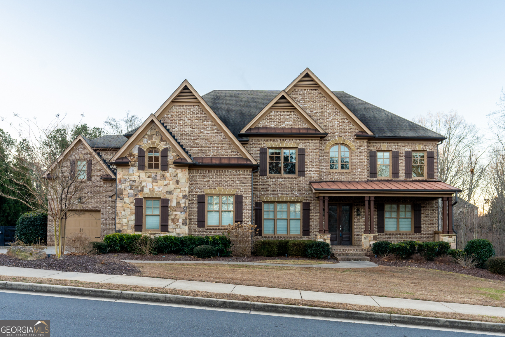 Located in the prestigious gated community of Kingsley Estates and within the top-rated Cambridge High School district, this exquisite home offers over an acre of private property and a thoughtfully designed floor plan that seamlessly blends style and function. The heart of the home is the oversized kitchen, which is truly a chef's dream. It features a new backsplash, Thermador stainless steel appliances, wine and beverage fridges, and a hidden walk-in pantry. This open kitchen flows effortlessly into two stunning living areasCoa grand family room with coffered ceilings, bookcases and a wall of windows, and a cozy keeping room with a stone fireplace and vaulted tongue-and-groove ceilings. Both spaces provide abundant natural light and direct access to a screened porch and deck that overlook the spa-like pool and hot tub. The level, grassy yard, surrounded by mature trees, offers unparalleled privacy and tranquility. The main level also includes a mudroom off the three-car garage for added convenience, a separate office, an en-suite guest room, dining room and butler's pantry. Upstairs, the primary suite is a luxurious retreat, featuring trey ceilings, his-and-her expansive walk-in closets, and a renovated spa-inspired bathroom. Secondary bathrooms throughout the home have been updated with marble vanities, and new lighting fixtures add a modern touch. The terrace level has been completely transformed into a fully functional apartment with private access. It includes a second kitchen, two bedrooms, one bathroom, tons of living space and a second laundry room, making it ideal for guests, multi-generational living, or rental income. With updates such as replaced windows and abundant built-in storage, this home combines timeless craftsmanship with modern amenities. The expansive lot, open layout, and serene outdoor spaces make it perfect for both entertaining and everyday living. DonCOt miss the chance to own this exceptional property in MiltonCoschedule your private tour today!