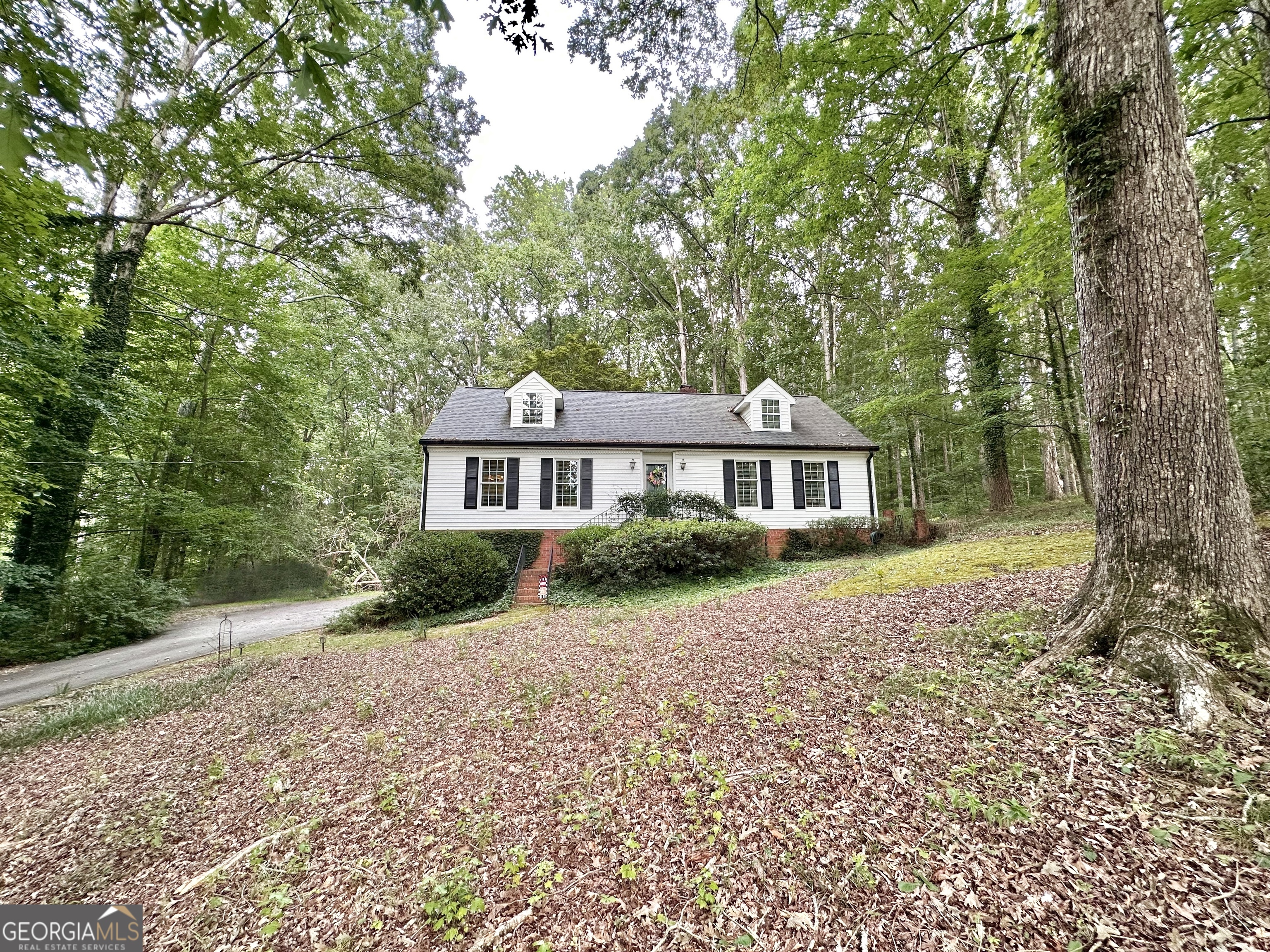58 Deerfield Road is a quiet, wooded oasis located only minutes from I-20 and the heart of Covington. 4 bedrooms and 4 full bathrooms on this 1.7 acre lot. Wood burning fireplace in living room with hardwood flooring in in kitchen, living room and dining room. Large primary bedroom with double doors that open to a screened in porch overlooking the shaded backyard. Spacious walk in closet. Large walk in shower with bench and separate soaking tub. Double vanity and private water closet. One additional room on main level with full bathroom and 2 bedrooms upstairs each with their own private bathrooms. Voluntary HOA would give you access to the community swimming pool, tennis courts and pond. Call to schedule a showing today!