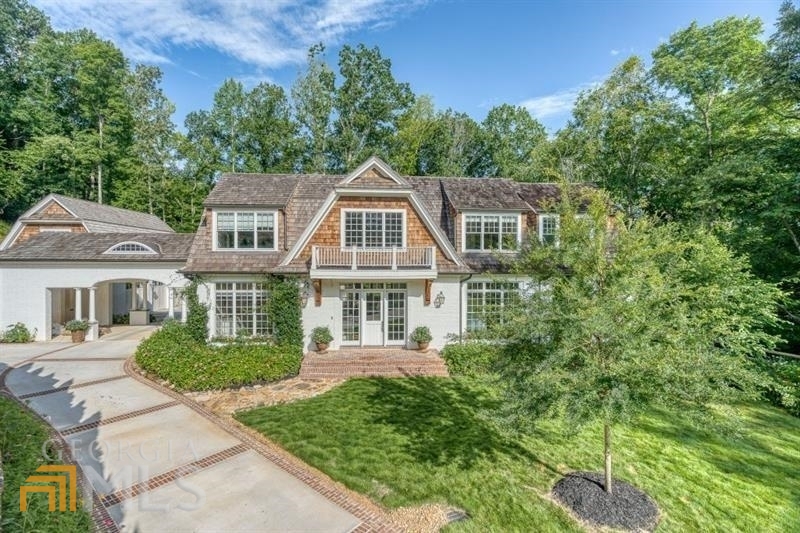 Long winding drive in a luxury enclave near Chastain Park leads to this amazing residence on 3.25 acre Nature inspired setting. Delight in magnificent perennial gardens surrounding this New England Coastal style home filled with vibrancy and sunlight. Finest materials and craftsmanship throughout define the character and allurement inside and out. Architectural authenticity abounds with the brick and shingle exterior, gas lanterns and cedar shake roof. Hand-hewn beams from Blue Ridge, wide plank hickory hardwoods, and shiplap accents are among the many interior finishes making this home so incredibly warm and inviting. Kitchen appointments include top of the line Wolf/SubZero appliances-refrigerator, freezer, induction cooktop, white craftsman cabinetry and expansive island and counters with exquisite Brazilian marble complete the quintessential chef-style kitchen. Main level master w/adjoining study and luxurious bath are the ultimate space for homeowner to relax and unwind with forest views of majestic 100 year old trees. Five secondary bedrooms with ensuite baths provide space and privacy. Extraordinary terrace level with stone/rustic wood beam accents. Lots of space for billiards and other games in open room adjacent to arched stone opening with barn door leading to huge media/entertainment room w/rounded walls/12' ceilings. Wow!- triple screens and bar. Spectacular oversized glass walled wine cellar for 1,000 bottles. Two bedrooms with ensuite baths. Ideal for in-law or au-pair.Additional large room for gym. Kick back/relax and dine on the delightful covered porch. Live in tranquility among birds, butterflies, level lawn and lush gardens in a totally private sanctuary. Truly this is home for those aspiring for a life well lived.