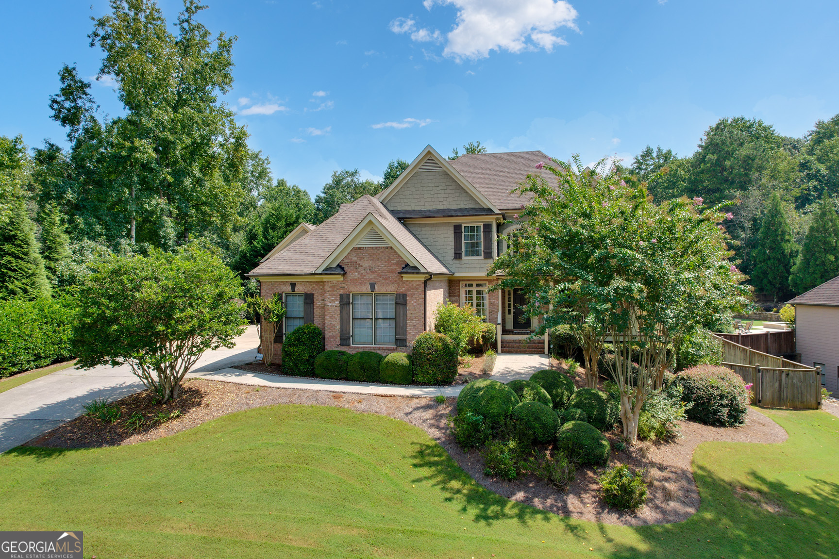 Stunning 6 Bedroom, 5 Bathroom Home on Basement with Home Theater - One of the Largest Floor Plans in the Highly Sought-After Orange Shoals Community! This home features a rare private studio apartment over the oversized 3rd Car Garage, perfect for a home office, bonus room or in-law suite. Upon entry, you are greeted by a two-story foyer with hardwood floors that flow seamlessly into the family room featuring a stone fireplace & access to the extended covered deck with wood-paneled ceiling. With views overlooking the large fenced-in backyard with a pergola, cafe lighting, patio stones & swings! Off the foyer, you'll find a versatile living room or office space, while the separate dining room features chair molding and a luxury linen light. Extensive Crown and Picture Rail Molding can be found throughout the Home. The chef's kitchen boasts custom cabinetry, luxury stainless steel appliances including double wall oven with side-swing doors & refrigerator with a beverage center plus double-door pantry. It also includes a breakfast bar with beadboard accent and an open breakfast area with access to the covered deck. The main level is complete with a generous bedroom and full tiled bathroom! Upstairs, the hardwood stairs lead into the hallway which features spacious bedrooms, including an en-suite. At the heart of it all is the Loft Room, a bright and airy space, with french doors and is perfect for gaming! The Owner's Suite offers a tray ceiling, views of the landscaped backyard and an adjoining spa-inspired bathroom with vaulted ceiling, double vanities, designer lighting, an enclosed tiled shower, and jetted tub. A must-see is the massive walk-in closet that makes this owner's suite a true sanctuary. There's even more: a Finished Basement includes a Home Theater complete with a Large Screen, Built-In Audiovisual Equipment and Speakers. Adjacent is the vast exercise/recreation room, unfinished storage areas including stubbing for a future bath! Enjoy neighborhood amenities such as a clubhouse, swimming pool, tennis courts, playground and tree-lined streets with community benches. Located just minutes from shopping, dining, and entertainment, including the city of Canton, Roswell, Milton and Woodstock this home has it all!