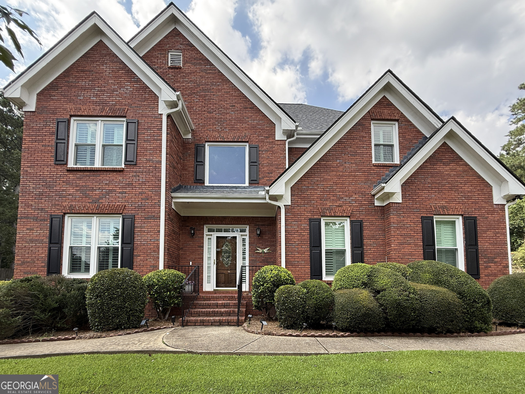 Welcome to 1205 Runnelwood Trail, a stunning 5 bedroom, 4.5 bath brick home located on a quiet cul-de-sac in the highly sought-after Brookwood Estates community. This spacious residence offers nearly 4,000 sq ft of living space with soaring ceilings, hardwood floors, and abundant natural light throughout. The main level features a grand two-story foyer, formal living and dining rooms, and a family room with a cozy fireplace that opens to the gourmet eat-in kitchen with granite counters, large island, breakfast bar, and white cabinetry. The oversized primary suite includes a spa-like bath with dual vanities, soaking tub, separate shower, and bidet. Upstairs bedrooms are generously sized and provide ample closet space. The fully finished terrace level is a true highlight, offering its own kitchen, bedroom, full bath, living area, and private entrance-perfect for in-laws, extended family, or rental opportunities. Outdoor living is equally inviting with a large deck overlooking the landscaped backyard. Additional features include a side-entry two-car garage, built-in bookcases, and two fireplaces. Located in the award-winning Brookwood School Cluster, with easy access to Scenic Highway, The Shoppes at Webb Gin, dining, parks, and commuter routes, this home blends luxury, functionality, and convenience.