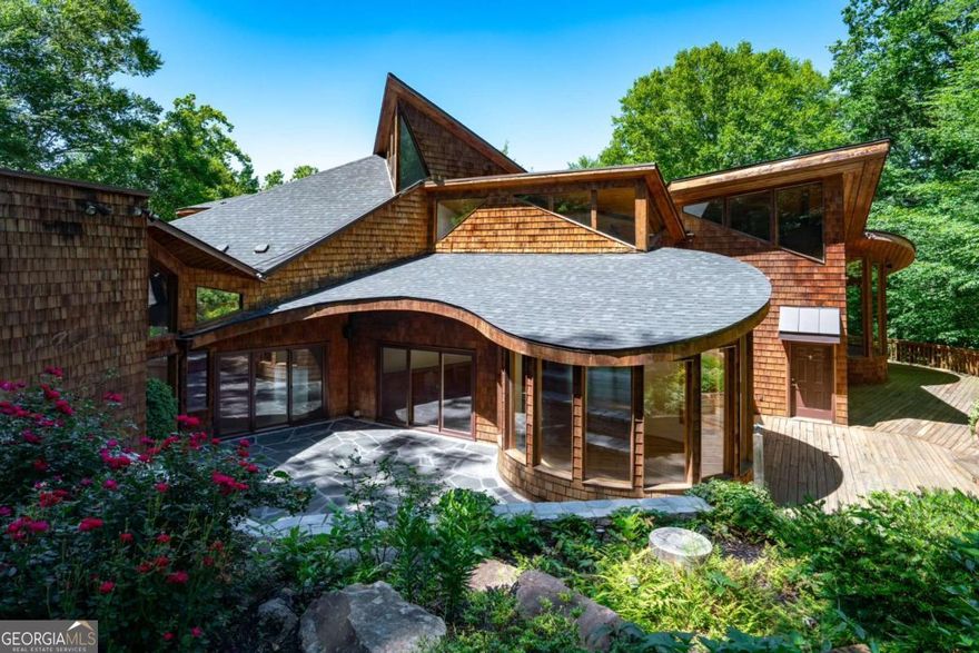 **RARE OWNER FINANCING AVAILABLE** Welcome to an extraordinary contemporary retreat: a true one of a kind masterpiece of modern architecture and perfectly situated within walking distance of the iconic Chastain Park. This stunning, custom-built 5-bedroom, 5.5-bath residence has been recently renovated to perfection, offering a seamless blend of sophistication, comfort, and connection to its natural surroundings.    From the moment you enter, you'll be captivated by the open, light-filled layout designed for effortless living and entertaining. Expansive windows and soaring vaulted ceilings create an airy sense of space, while circular glass walls frame breathtaking panoramic views of Nancy Creek: blurring the lines between indoor and outdoor living.    Designed with versatility in mind, the home features three fully equipped kitchens ideal for hosting, preparing gourmet meals, or accommodating multi-generational living with ease.    Step outside to your private oasis: multiple decks, serene patios, and charming gazebos offer countless spaces to unwind and take in the peaceful, wooded surroundings. Expertly landscaped, terraced gardens further enhance the home's tranquil setting, creating a lush retreat right in the heart of the city.    A private studio apartment with its own entrance provides the perfect space for guests, extended family, or a home office.    Whether you're seeking a serene sanctuary immersed in nature or an entertainer's dream home, this remarkable property embodies the perfect balance of contemporary luxury and timeless beauty - all within one of Atlanta's most coveted neighborhoods.