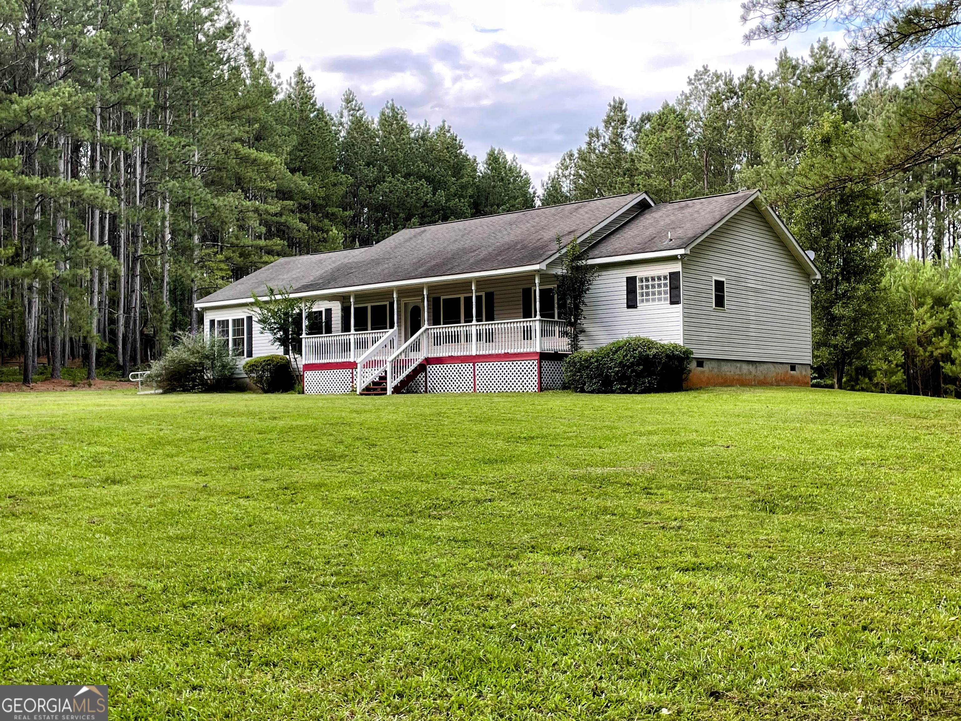 Discover your private oasis on over 10 acres of wooded land, offering unmatched tranquility with minimal upkeep. This stunning home features a rocking chair front porch, a spacious owner's suite with dual baths (shower and whirlpool tub) and a large walk-in closet, and a split bedroom plan for privacy. The bright kitchen boasts of natural wood cabinetry, a central island, and a breakfast bar, flowing into a dining room with scenic views and access to a large back deck-perfect for entertaining. Enjoy versatile living spaces with a cozy keeping room, family room, sitting room, office, and a practical laundry/mudroom. Equestrian amenities include a 4-horse stable, outbuilding, and lean-to, plus an RV electric hookup. A detachable 27-foot ramp to the side entrance ensures seamless accessibility, while storm doors at all three entrances bolster security and protection. Located minutes from Lake Hartwell and 30 minutes from UGA and downtown Athens, this retreat blends rural charm with modern convenience. Embrace your dream lifestyle today!