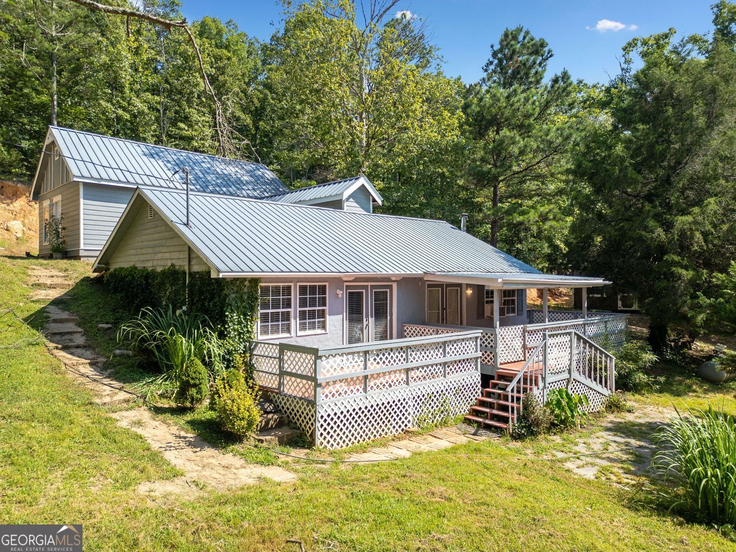 Welcome to your own peaceful escape! Nestled on 1.6 secluded acres, this 2-bedroom, 2-bath cabin offers the perfect blend of rustic charm and modern comfort. Relax on the porch, or explore your wooded surroundings for total privacy and tranquility. Inside, you'll find an open-concept living area with warm wood finishes and abundant natural light. The kitchen flows seamlessly into the living space, making it ideal for gatherings. One of the bedrooms is currently set up as a game room with a pool table-perfect for entertaining or easily converted back into a guest suite or home office. The primary bedroom is located upstairs with a separate entryway for privacy and convenience. . Outside, a large storage outbuilding provides space for your tools, recreational gear, or workshop needs. Whether you're looking for a weekend getaway, vacation rental potential, or a full-time residence, this special property offers a rare combination of privacy, natural beauty, and versatility.
