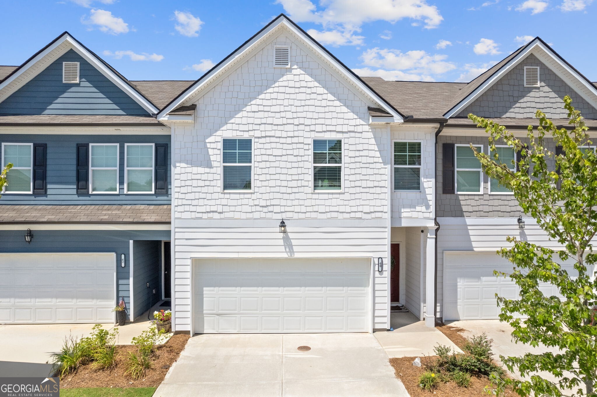 Better Than New in Hoschton! Welcome to this stunning, move-in-ready townhome in the highly sought-after Cambridge at Town Center. This 3-bedroom, 2.5-bath gem has all the charm of new construction plus thoughtful upgrades you simply won't find in a builder-basic home. From the moment you pull up, you'll love the white exterior that gives this home gorgeous curb appeal. Inside, luxury vinyl plank flooring flows throughout the main level, accented by custom shiplap walls and a cozy electric fireplace that sets the tone in the family room. The open-concept kitchen is a showstopper, featuring a center island perfect for casual dinners or entertaining, along with a dedicated breakfast area for morning coffee or weekend brunch. Upstairs, the spacious primary suite feels like a retreat with a designer accent wall, a large walk-in closet, and a beautifully appointed bath with double vanities. Two additional secondary bedrooms share a stylish hall bath, offering plenty of space for guests, kids, or a home office. Step outside to enjoy your private, fenced backyard a rare find in townhome living! Whether you're hosting a summer BBQ or letting the pup roam, this space is as functional as it is charming. Located in a community with fantastic amenities including a pool and cabana, this home truly checks every box. It shows like a model and is ready for its next chapter