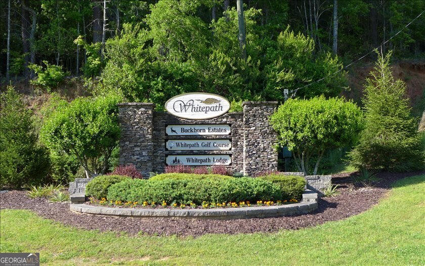 Tucked away on 0.97 acres in the desirable Buckhorn Estates community, this homesite offers privacy, paved road access, and the perfect blend of natural beauty and convenience. Nice, gentle sloping terrain that is ready for your mountain home. You'll love the peace & quiet while also being able to stay connected with high-speed internet and cable TV available. Enjoy nearby local favorites like Cress Creek Farm Store, Roo Vineyards, and Ellijay Mushrooms' farm store-all just minutes from your this homesite. Community perks include a county-owned river park, an 8-acre stocked fishing lake, and Whitepath Golf Course, a public 18-hole course you can reach by golf cart. Low HOA dues of only $225/year keep living here simple and affordable. With Gilmer County's no school tax for residents 65+ and a community that does not allow short-term rentals, Buckhorn Estates is ideal for those seeking a serene mountain retreat or full-time residence. Come discover this peaceful lot and start building your mountain dream today!