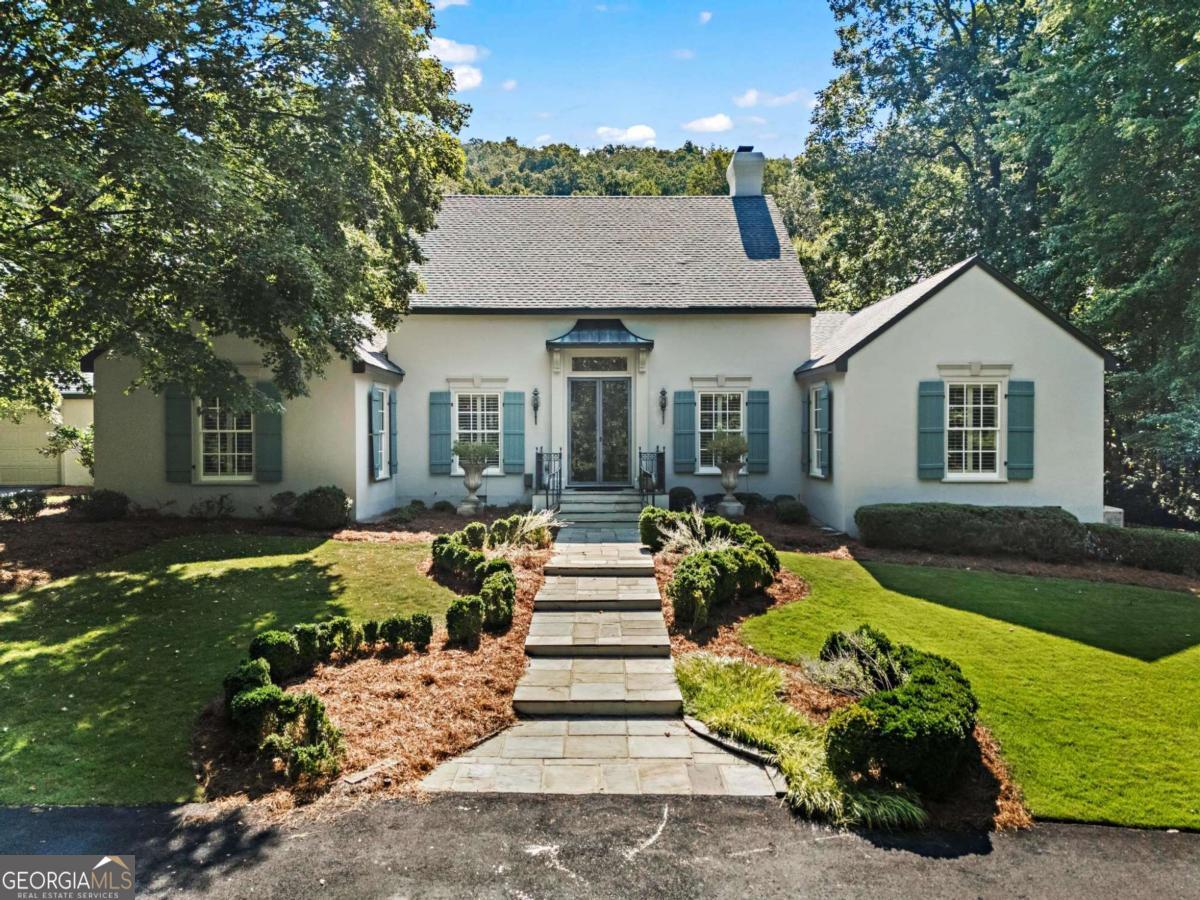 Extremely rare opportunity to live in this exquisite neighborhood on three beautiful private acres. The expansive main level is perfect for indoor and outdoor entertaining, with spacious rooms extending nearly the width of the house, looking out to layers of beauty starting with the mature garden, the pool, and then the mountain. The backyard playground is resplendent with a saline pool, a pool house with fully equipped outdoor kitchen, a full bathroom and a separate changing room. The tennis court was recently resurfaced and pickleball lines were added. Additional features include a vegetable/cutting garden, a new tool house, a dog run and golf cart trails. Interior features boast a carved wood double front door sourced from Europe that opens into a foyer with an arched wood architrave and tile flooring, also from Europe. A Generac generator ensures the house maintains power in severe weather conditions. Hike the mountain directly from your backyard then return and cool off in your pool. The entertaining opportunities both inside and outside are endless. Situated about 400 feet from the base of Kennesaw Mountain, this private oasis is waiting for your enjoyment.