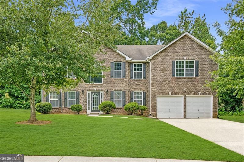 Welcome to 5179 Miller Woods Trail and expansive 6 bedroom, 3 bathroom home is tucked away in the serene, established community of Miller Woods-offering the perfect balance of space, comfort, and convenience just minutes from I-20, I-285, and all that Metro Atlanta has to offer. Step inside to a dramatic two-story foyer that creates an open, airy welcome. On the left side, you'll find formal living and dining rooms-ideal for hosting family gatherings or enjoying quiet evenings at home. Just off the right side of the foyer is the perfect flex space for a guest room, home office or study complete with a full bathroom. At the heart of the home lies the spacious kitchen, well-appointed with white cabinetry, stainless steel appliances, granite countertops, a gas range, and a cozy eat-in breakfast area. Check out the large patio-perfect for dining al fresco or relaxing under the stars. The sunken family room offers a warm, inviting retreat with a ceiling fan, access to the two-car garage, and a private staircase leading to the oversized primary suite. Upstairs, the main staircase brings you to five generously sized bedrooms with tray ceilings and large closets, sharing a full hall bath. The luxurious primary suite feels like its own private wing-featuring an oversized walk-in closet, dual vanities, a deep soaking tub and a separate shower. With dual staircases and the optional 6th bedroom on the main level, this home offers exceptional flexibility for multi-generational living, guests, or a dedicated workspace. Situated on a large lot on a quiet street, this home combines everyday livability with special touches throughout. Don't miss the opportunity to call this spacious gem your home-schedule your showing today!