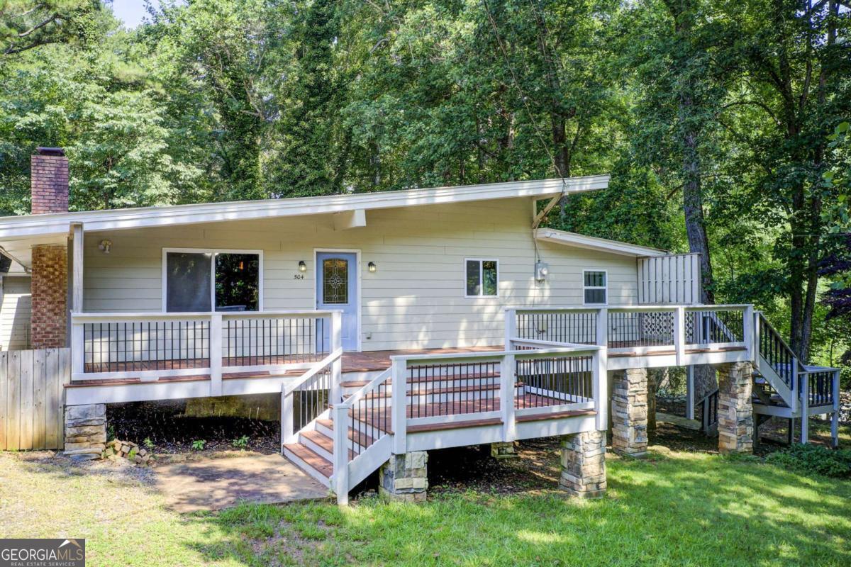 Lakefront Opportunity - Private Dock on Lake Allatoona 3 Living Spaces No HOA Victoria Cottages Welcome to your future lakefront sanctuary-just 30 steps from the water and your very own private deeded dock on the shimmering shores of Lake Allatoona. Nestled in the coveted Victoria Cottages community with no HOA, this rare property offers a one-of-a-kind opportunity: three distinct living spaces on a generous 0.4-acre lot. Whether you're looking for a full-time residence, a weekend retreat, or an income-producing getaway, this home delivers unmatched flexibility and value. The main house features 3 bedrooms and 2.5 bathrooms, highlighted by a soaring vaulted ceiling and a cozy stone fireplace-perfect for relaxed evenings after a day on the lake. The open-concept layout connects the family room, dining area, and kitchen, making it ideal for entertaining or simply unwinding in comfort. Just steps away, the carriage house offers a private 1-bedroom suite with a bonus room, full kitchen, living room, and laundry-ideal for guests, extended family, or potential rental income. The terrace-level apartment includes a full bath and offers even more flexible living or storage space. Tucked beneath a canopy of trees, this lakeside hideaway is full of potential. Updates such as a metal roof, newer siding, HVAC, and windows provide a strong foundation for your personal touch. Enjoy morning coffee on your large front deck, host weekend gatherings under the stars, or take a short stroll to the dock for a spontaneous boat ride or swim. And if you're dreaming bigger-the existing swim dock can be upgraded to a full boat dock (approval required from the Corps of Engineers). Located in the sought-after Etowah High School district, with quick access to I-575, Downtown Woodstock, Towne Lake, and The Outlet Shoppes of Atlanta, this home balances peaceful lakeside living with the convenience of nearby shopping, dining, and top-rated schools. This is more than a handyman special-it's a Lake Allatoona lifestyle opportunity waiting for your vision. Whether you're dreaming of summer weekends on the water, cozy winter nights by the fire, or income-generating potential, the possibilities here are endless. Your lake dream starts now. Schedule your private tour today and unlock the full potential of this lakeside gem.