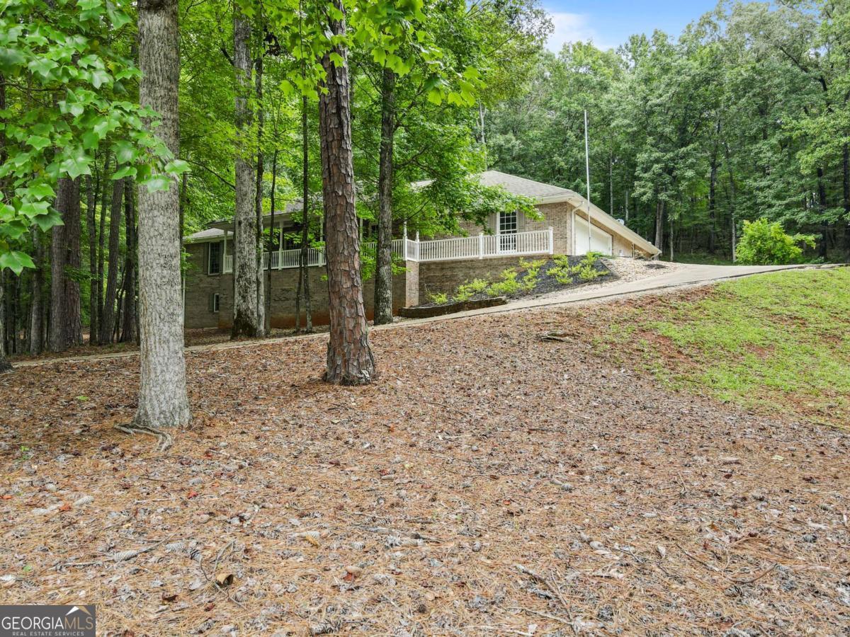 Discover your dream retreat with this stunning four-sided brick ranch home, nestled on a generous 4-acre lot just a short walk from West Point Lake. Boasting over 3,000 square feet of thoughtfully designed living space, this residence combines modern comfort with serene, private surroundings. Featuring 4 oversized bedrooms, including 2 luxurious master suites, this home offers ample room for relaxation and entertainment. Each master suite opens to the expansive covered rear porch, providing a perfect setting for enjoying your peaceful surroundings and watching local wildlife. The bedrooms are complemented by huge walk-in closets and 3.5 well-appointed bathrooms, ensuring convenience and ample storage throughout. The home is equipped with separate HVAC systems and water heaters for each side, ensuring efficient climate control and lower utility bills. The interior is thoughtfully designed with 36" inch doorways for easy access and comfort. An enormous, heated basement garage/workshop offers versatile space for all your recreational tools and equipment, with additional storage for your boat or other gear in the garage below the home. The fenced-in yard area and two large porches offer plenty of outdoor space to enjoy, while the proximity to four boat ramps within just 3 miles makes this home a haven for water enthusiasts. Located within a great school district, including Hollis Hand Elementary, Gardner Newman Middle, and LaGrange High School, this property offers an ideal blend of convenience, privacy, and natural beauty. Don't miss the opportunity to make this exceptional property your own!