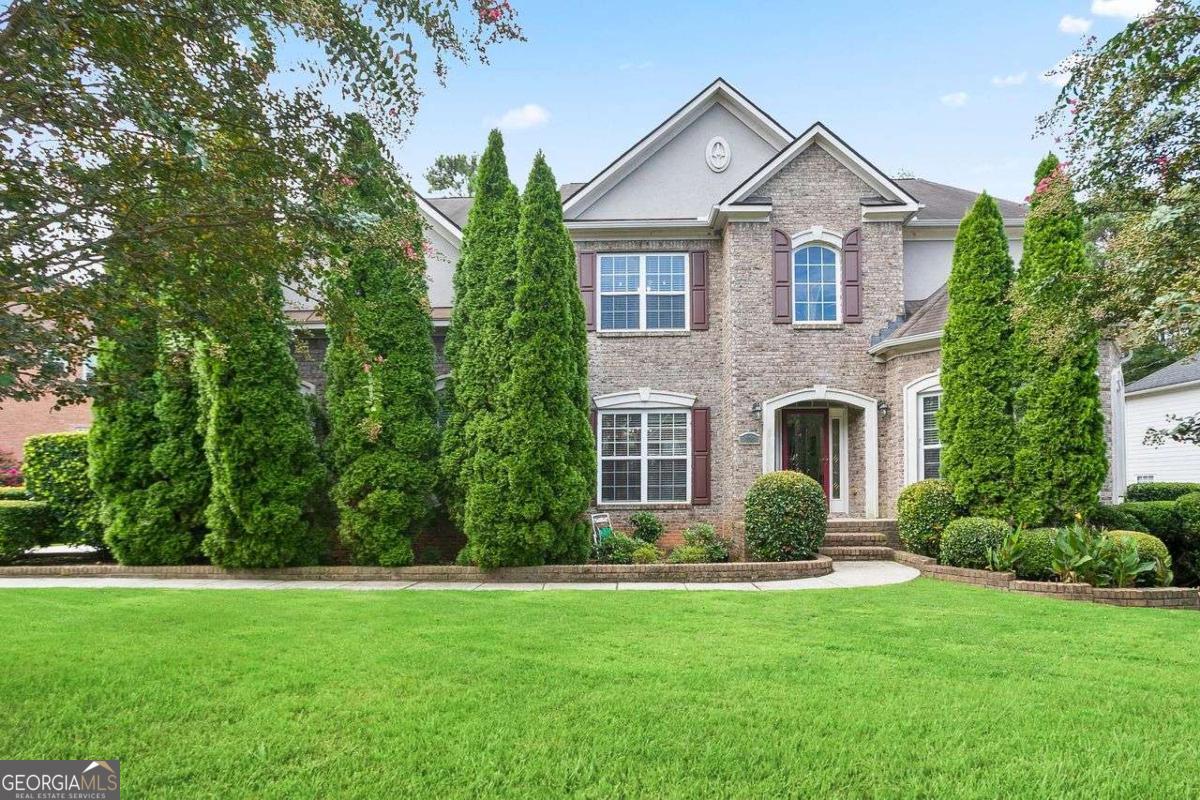 Located in the prestigious swim, tennis, and golf community of The Links, this beautifully maintained 5-bedroom residence offers three complete levels of living space, including a fully finished basement. The exterior features a classic brick front elevation with exceptionally kept landscaping, setting the tone for the quality throughout. Inside, you'll find a two-story living room filled with natural light and a spacious kitchen complete with granite countertops, double ovens, and abundant cabinetry. The main level also includes a bedroom with a full bath, ideal for guests or multi-generational living. Upstairs, you'll find four generously sized bedrooms, including an expansive owner's suite with dual closets and a large private bath. The finished basement provides an additional full level of living, featuring a second full-size kitchen with appliances, breakfast bar, family room, and two versatile rooms perfect for office space, fitness, or hobbies. Outdoor living is maximized with a screened-in patio on the second level and a covered patio at the basement level, both overlooking a spacious backyard with stunning views of hole #15 of the golf course. This home offers the perfect combination of luxury, function, and community amenities, making it an ideal choice for family living in one of the area's most sought-after neighborhoods.