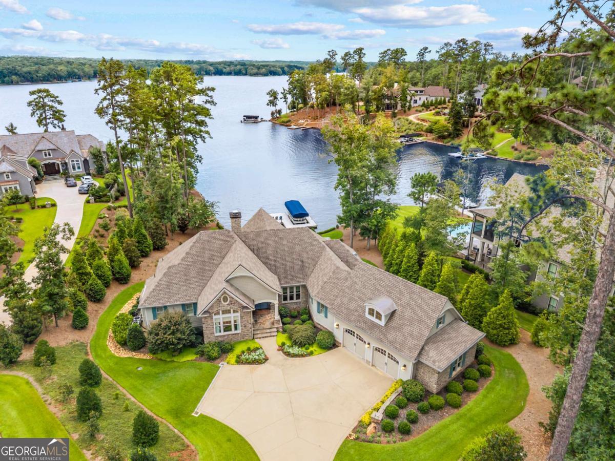 DREAM LAKE HOUSE AT LAKE OCONEE Welcome to your breathtaking lake house retreat on the pristine shores of Lake Oconee, located in the coveted Horseshoe Bend neighborhood at Reynolds Lake Oconee. This property isn't just a house; it's an experience, a harmonious blend of luxury, comfort, and natural beauty. Location, Location, Location Nestled in one of the most desirable lakeside communities, this home offers more than just picturesque sunset views over the water. It's a stone's throw from Richland Pointe and just a short boat ride to the famed Ritz Carlton, making it an ideal retreat for anyone looking for a blend of exclusivity and accessibility. Inside the Home This stunning residence was exquisitely designed, featuring an open floor plan that seamlessly integrates indoor and outdoor living spaces. Imagine waking up to breathtaking lake views from the spacious, sun-drenched great room, or enjoying your morning coffee on the screened porch that feels like part of the home itself. *5 spacious bedrooms, including a primary suite on the main level, perfect for relaxation after a long day on the water. *A versatile bedroom/office on the main level caters to modern lifestyle needs. *The ultimate chef's kitchen, equipped with stainless steel appliances, a walk-in pantry, and an oversized island perfect for entertaining. *An adjoining bar area complete with a wine fridge - ultimate sophistication right in your home. Downstairs Delight With an elevator taking you to the terrace level, find a large family room, a secondary kitchen, and a second screened porch leading to the expansive backyard. The home's design ensures that each level offers uninterrupted views of the serene lake, making every room feel like a unique getaway. Outdoor Luxury Step into a beautifully landscaped backyard with plenty of room for a pool, if you choose. The yard is perfect for hosting gatherings or enjoying quiet evenings by the fire pit. Convenient access to your private dock ensures that endless water adventures await you and your guests. Opportunities Await For those considering a lifestyle change, opportunities abound at Reynolds Lake Oconee. A Reynolds membership is available, offering exclusive access to the community's world-class amenities. Whether it's a round of golf, a day at the spa, or a meal in one of the neighborhood's gourmet restaurants, you're stepping into an enriched lifestyle. We welcome you to experience this remarkable home firsthand.