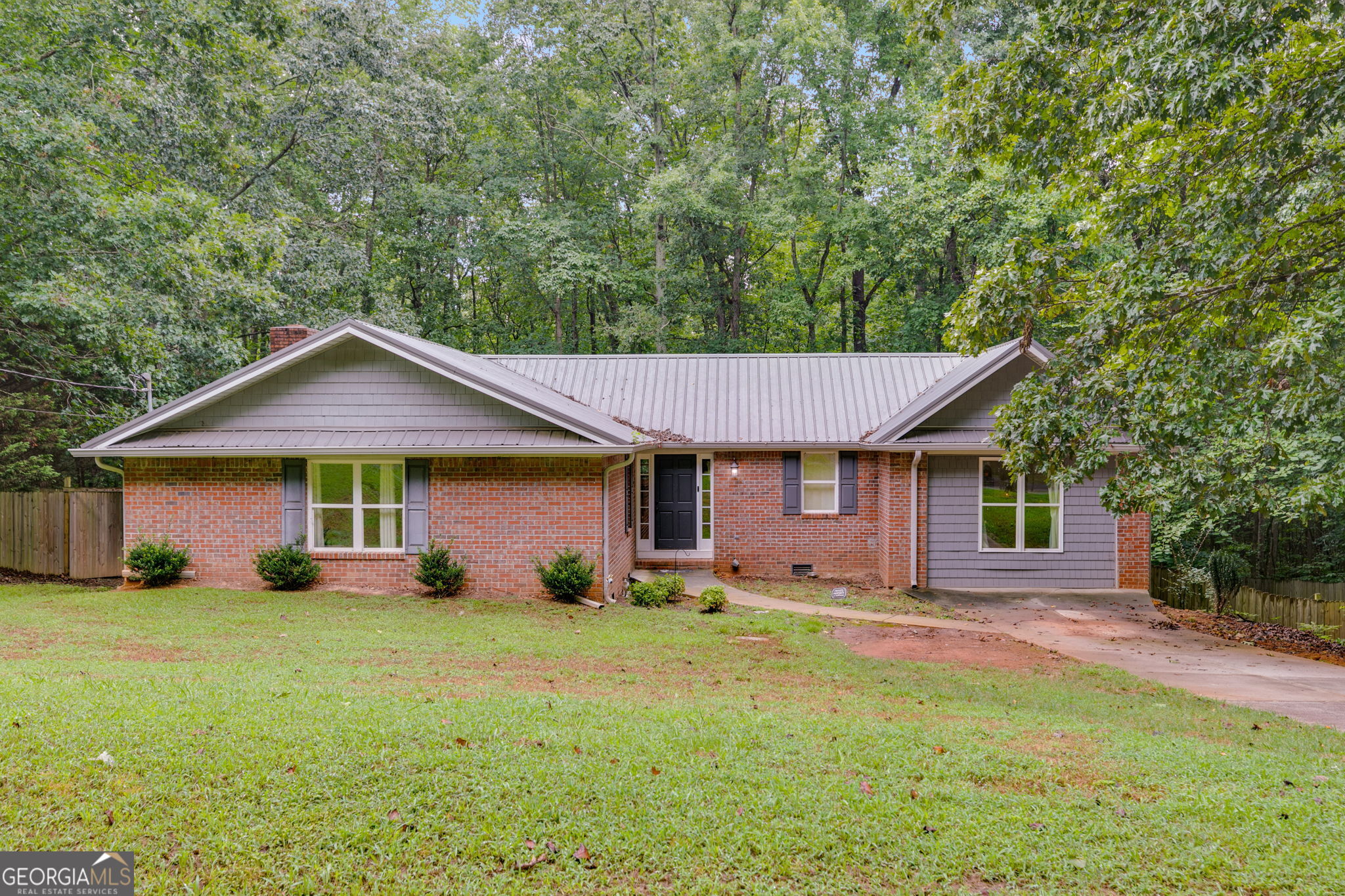 Charming 4-sided brick ranch just minutes from downtown Carrollton and I-20. This 3-bedroom, 2-bath home features a spacious open-concept layout that connects the living area and kitchen, perfect for everyday living and entertaining. The split-bedroom floor plan offers added privacy and flexibility, making it ideal for families or guests. A durable metal roof provides long-term peace of mind, while the large back deck and fully fenced yard create a great outdoor space for relaxing, hosting, or letting kids and pets play. Conveniently located just 10 minutes to both I-20 and downtown Carrollton, this home combines comfort, functionality, and an unbeatable location.