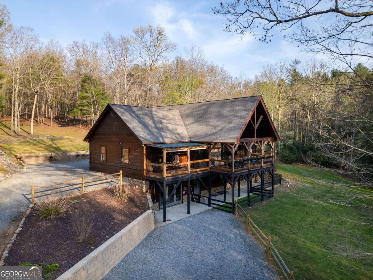 This beautifully renovated mountain home offers the perfect blend of comfort, space, and privacy - tucked away on 9.6 acres across TWO SEPARATE TRACTS. Keep both for added space or sell the raw land later for flexibility and POTENTIAL RETURN. A peaceful CREEK runs just steps from the back door, creating your own private oasis. The home received a BRAND-NEW ROOF in March 2025 for added peace of mind. Also BRAND-NEW FLOORING throughout the home, updated photos added! Outside, you'll find a 20x30 spray-foam INSULATED GARAGE with power, a 2-car carport, and a covered, fenced dog run for your furry companions. Inside, the finished basement includes a second living area, fourth bedroom, third full bath, rec/office space, laundry room, and abundant storage. There's also a dedicated workroom with TOOLS NEGOTIABLE WITH SALE. MOST FURNISHINGS ARE NEGOTIABLE WITH SELL, making this home nearly MOVE-IN READY. The sellers are also including a 1-year HOME WARRANTY for the buyers' added peace of mind. Come experience the solitude and space this mountain retreat has to offer! PLEASE NOTE: A pre-approval letter or proof of funds is required prior to scheduling a showing. As the home is occupied, please provide at least one hour's notice for all showings.
